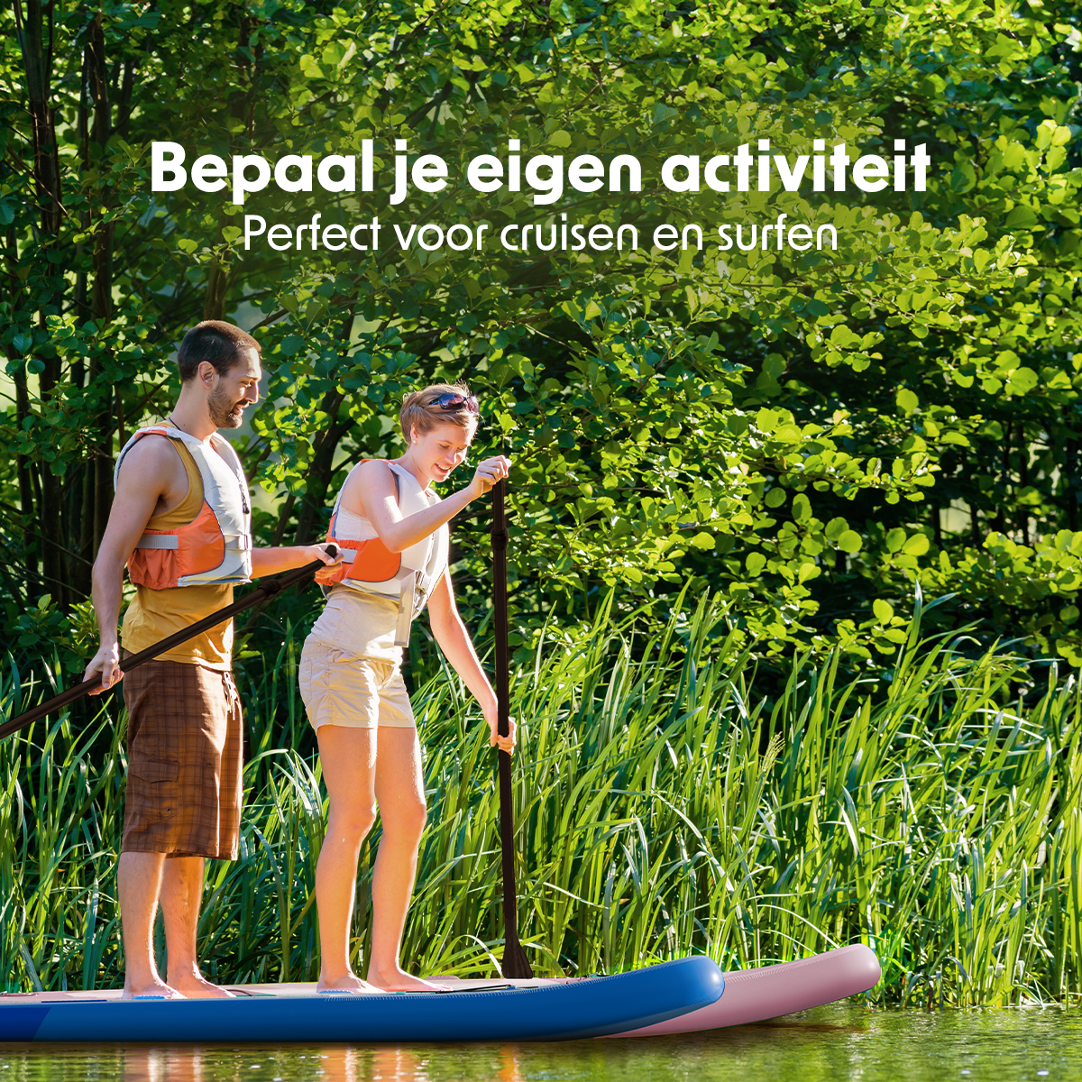 Een man en een vrouw peddelen op een blauwe en roze paddleboard, omringd door groen gebladerte.