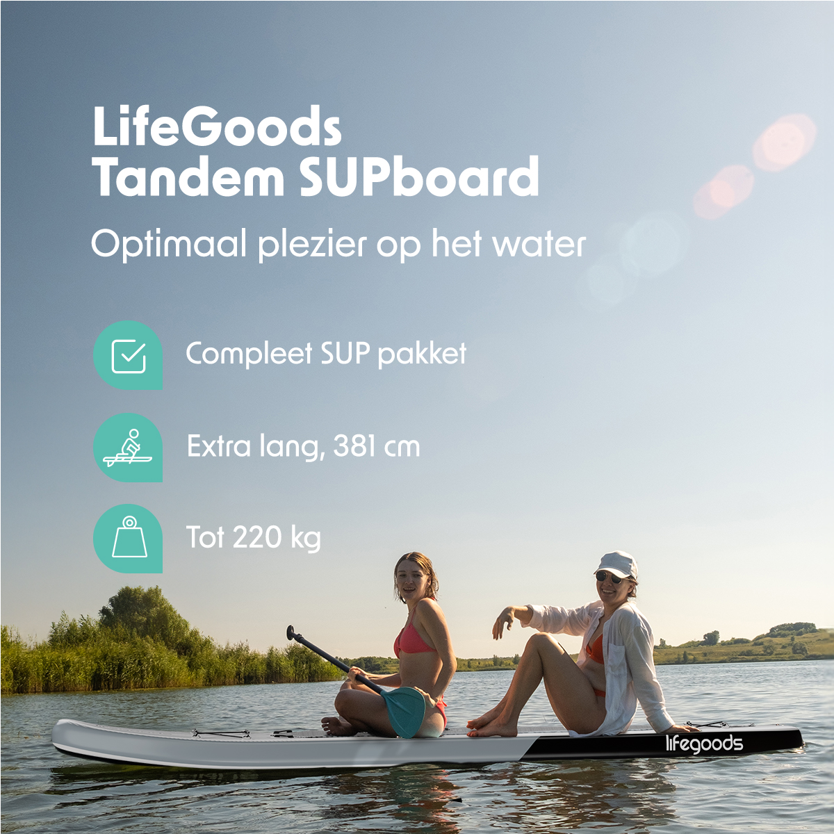 Twee vrouwen zitten op een LifeGoods tandem SUPboard op het water, met bomen op de achtergrond, onder een heldere hemel.