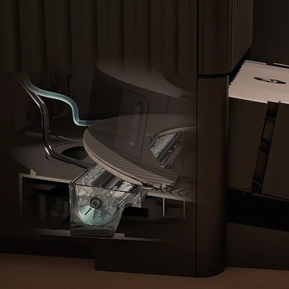 Ilustracja przedstawia wewnętrzny mechanizm czarnej podstawy odkurzacza z przezroczystym zbiornikiem na wodę.