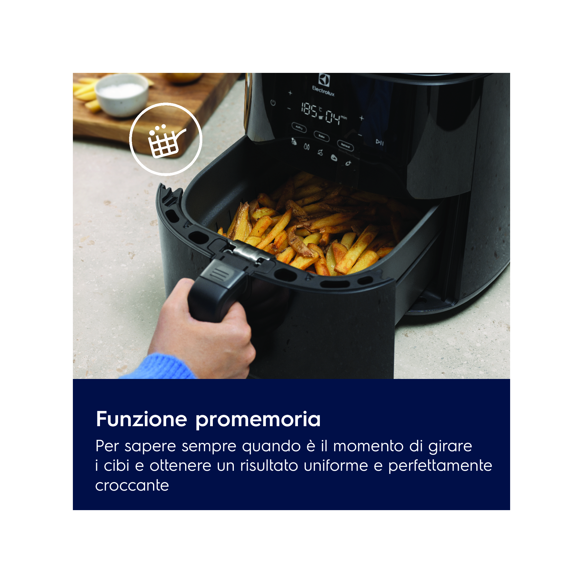 Friggitrice ad aria nera Electrolux con patatine fritte che vengono rimosse dal cestello da una mano.