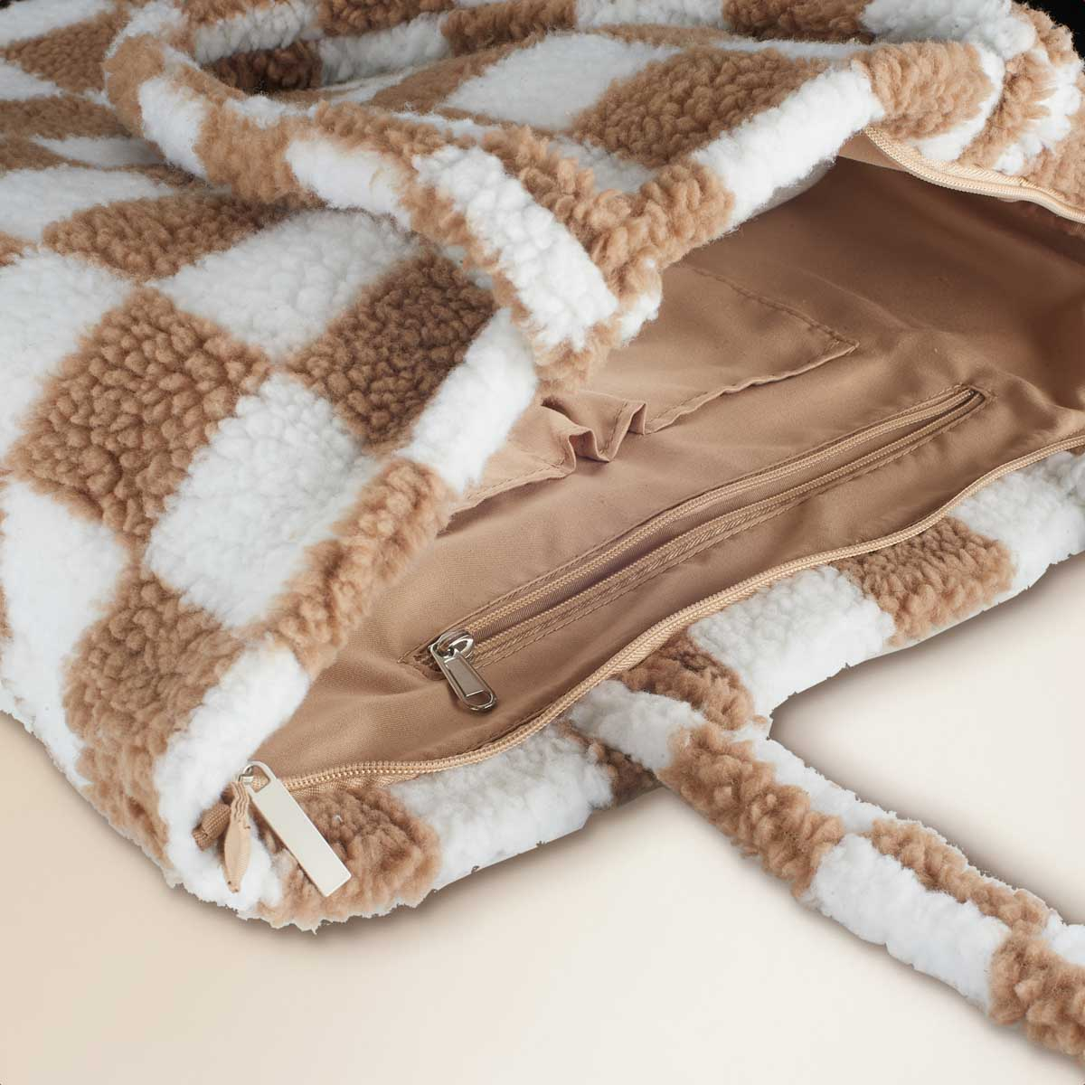 A view inside a white and brown checkered tote bag reveals a zippered pocket and soft lining.