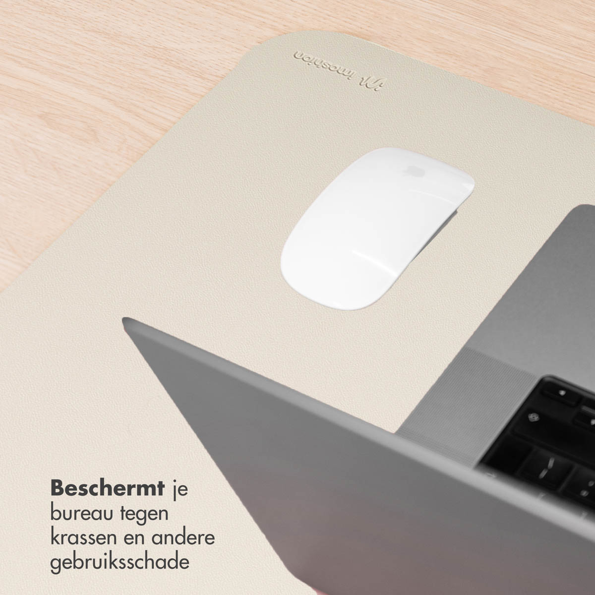Laptop, mouse e tappetino beige su una scrivania in legno chiaro. Il laptop è aperto e il mouse è di fianco.