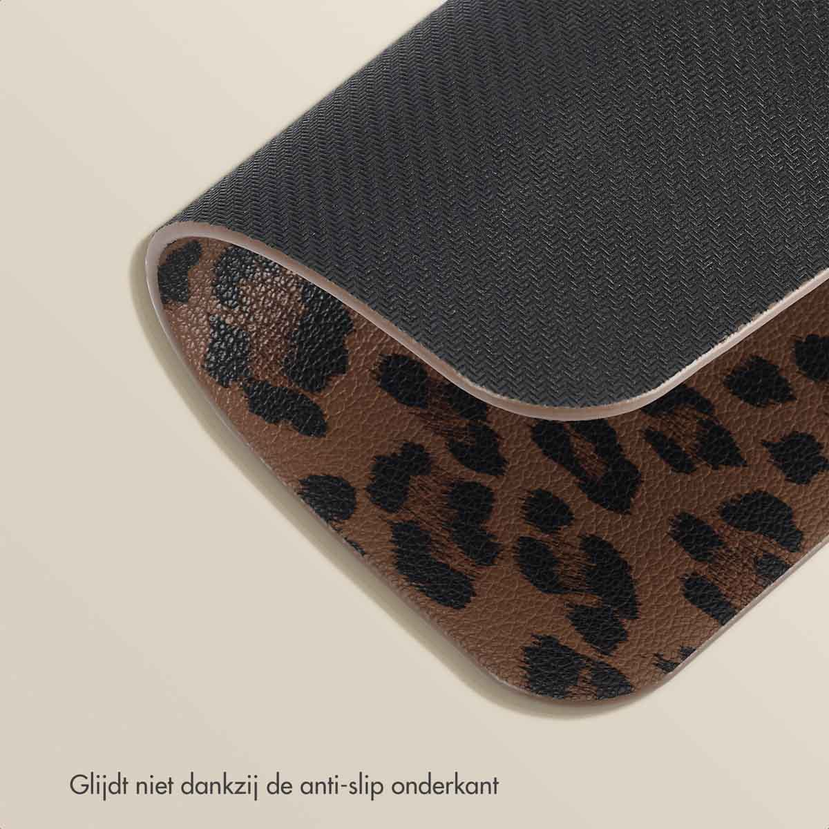 Angled view of a leopard print surface with a black anti-slip backing and Dutch text.
