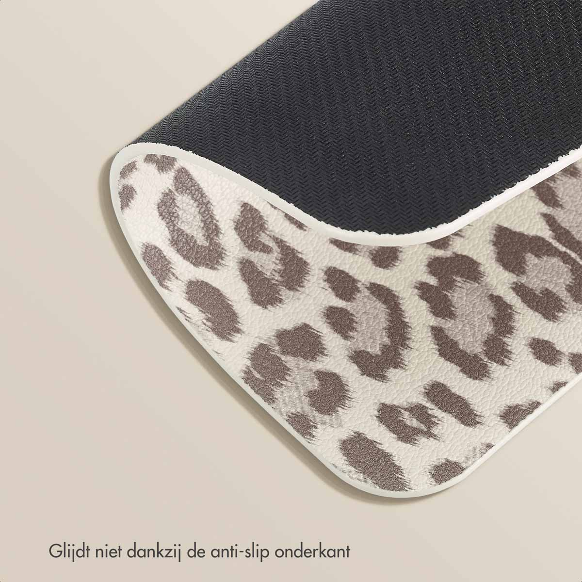 Close-up of a leopard print mousepad, showing the textured surface and non-slip black rubber base.
