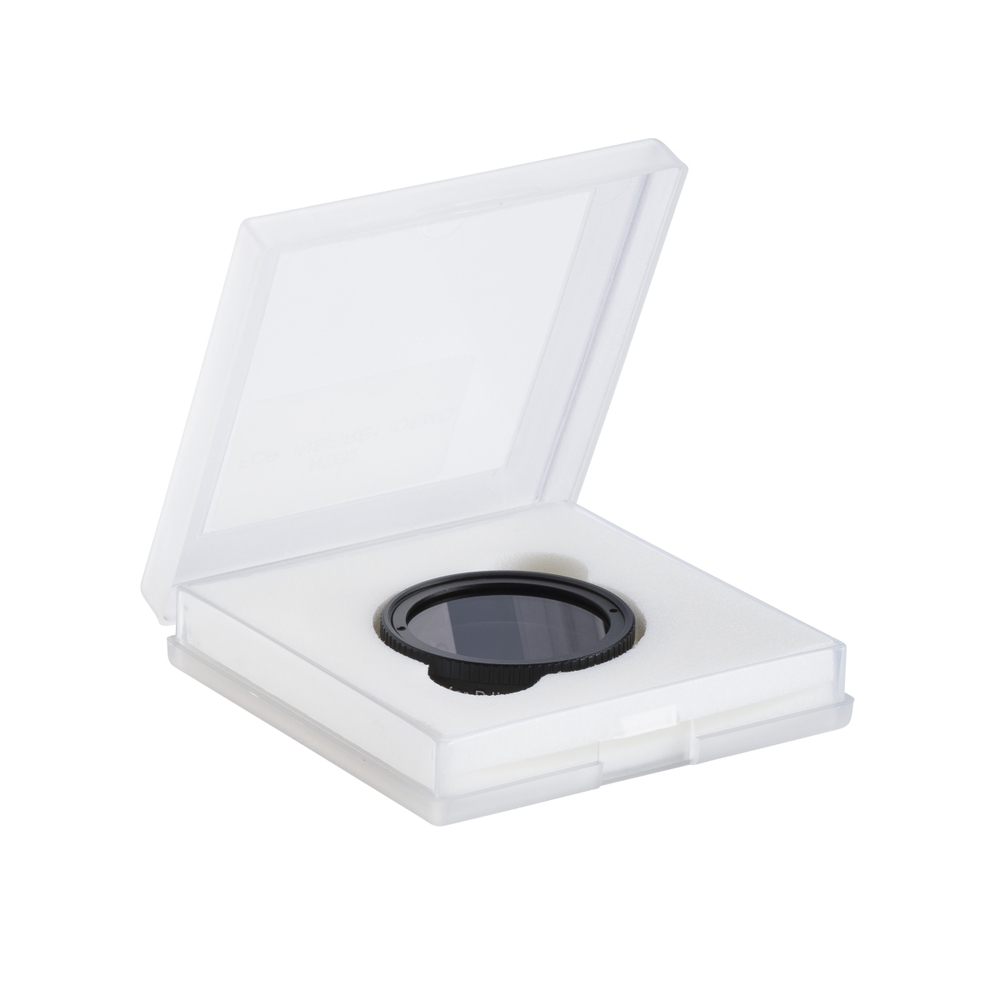 Een zwart lensfilter voor DJI-drones bevindt zich in een doorzichtige, vierkante, open case met witte schuimvulling.