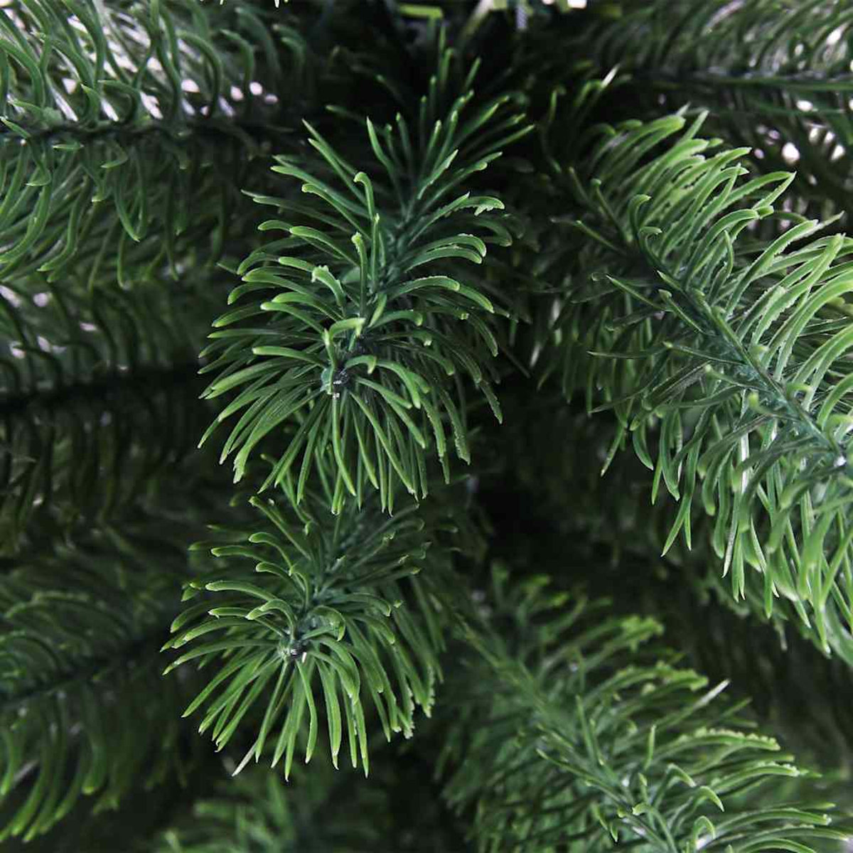 Nahaufnahme von grünen künstlichen Weihnachtsbaumzweigen.