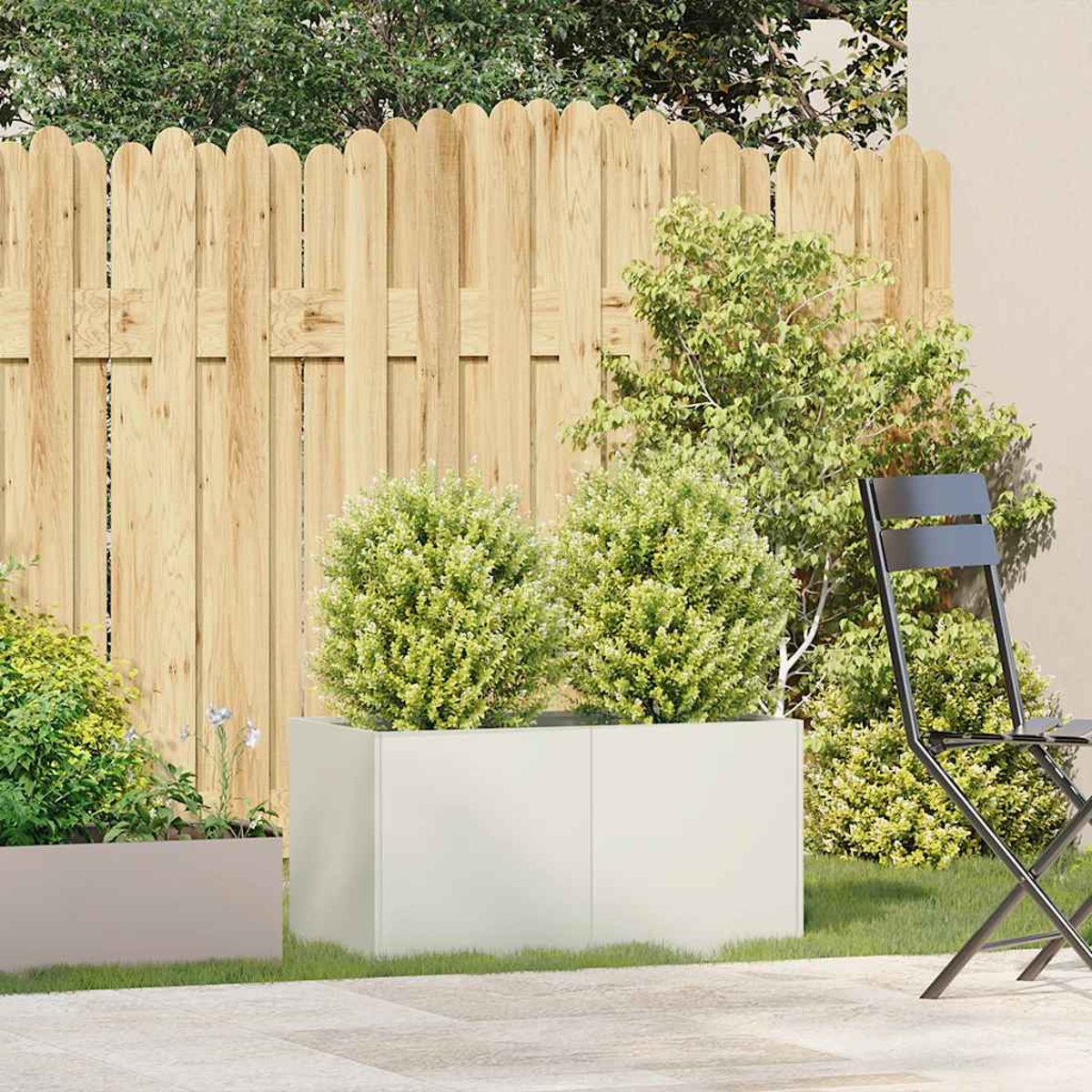 Scena all'aperto con una fioriera bianca contenente arbusti, una recinzione in legno e una sedia in metallo nero.