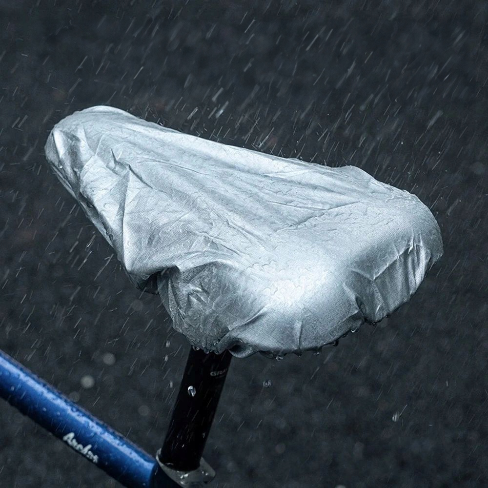 Siedzisko rowerowe jest pokryte srebrnym wodoodpornym pokrowcem podczas deszczu.
