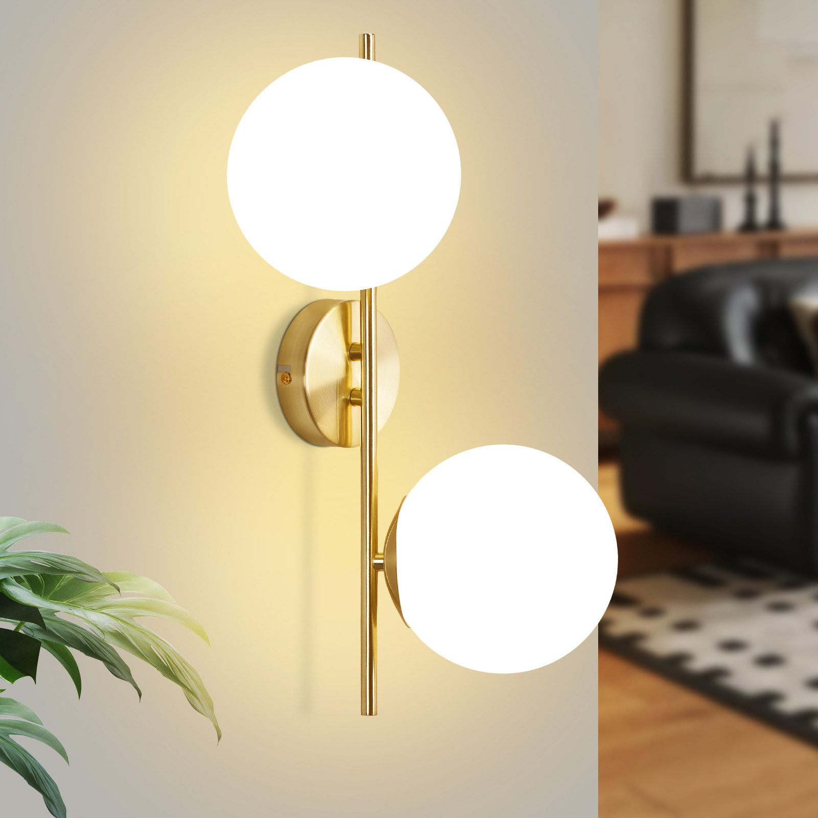 Una applique da parete dorata con due paralumi rotondi in vetro bianco, montata su una parete.