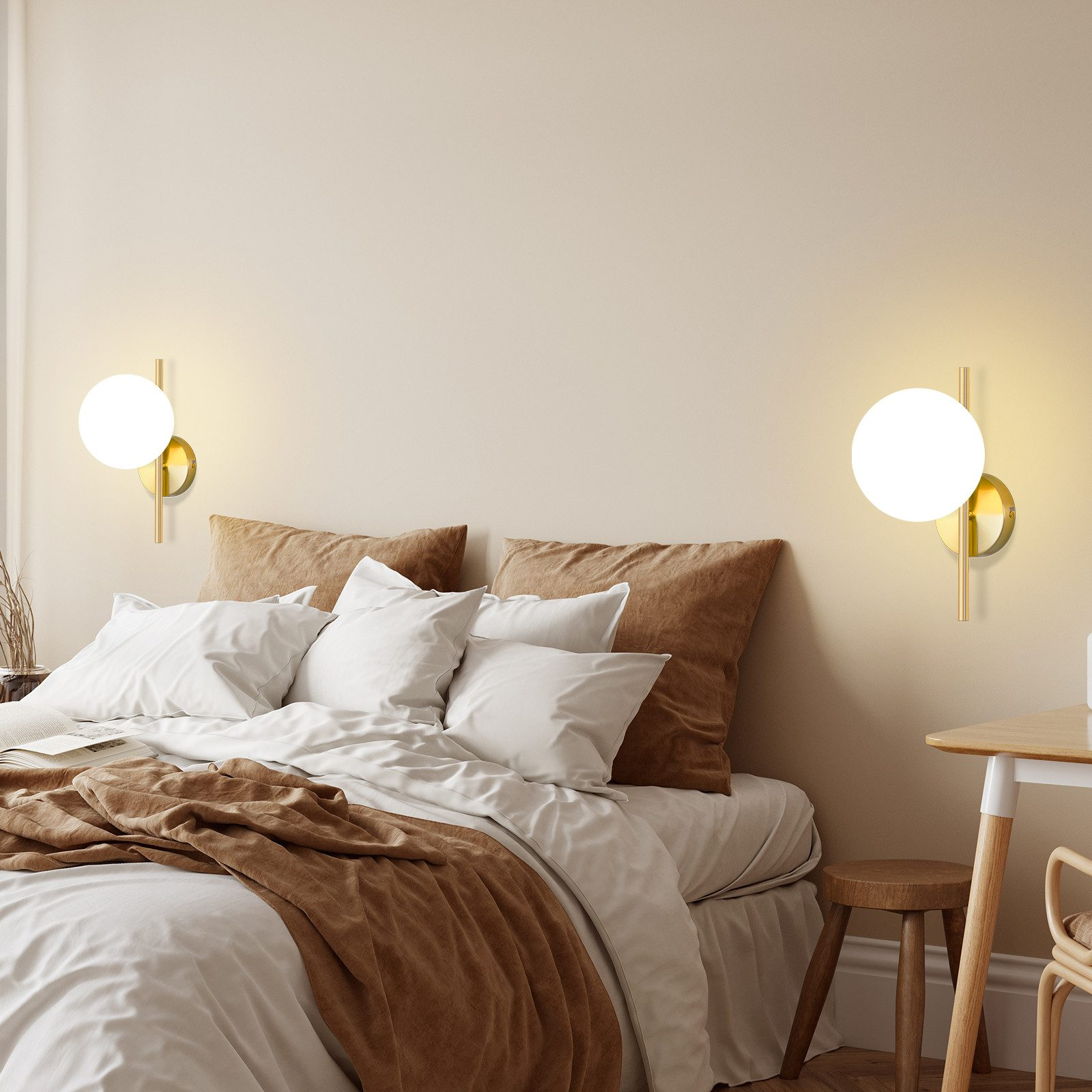 Scena di camera da letto con letto, cuscini e due moderne lampade da parete con paralumi bianchi rotondi e finiture dorate.