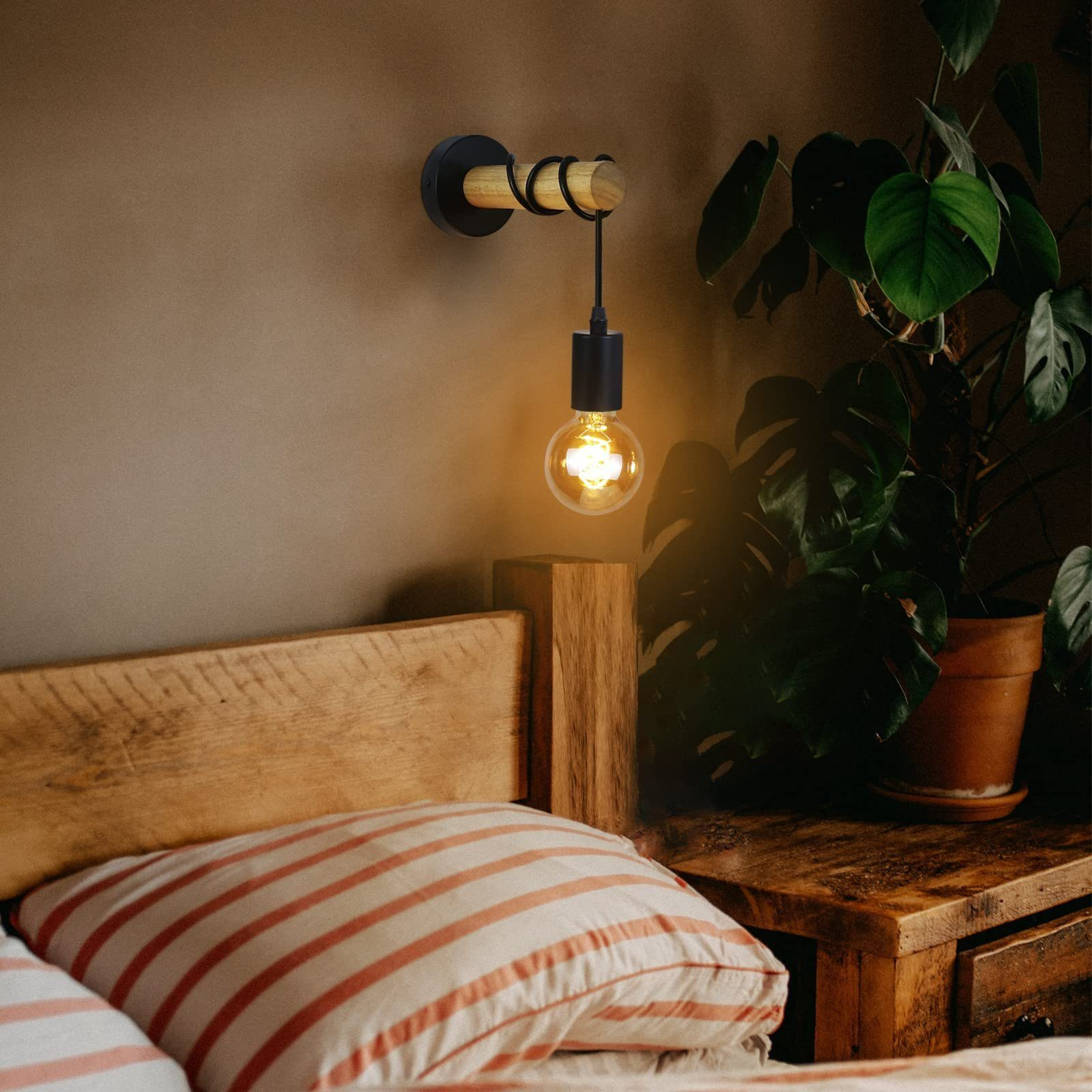 Scena di camera da letto con testiera in legno, cuscino a righe e una lampada da parete con una lampadina visibile, accanto a una pianta in vaso.