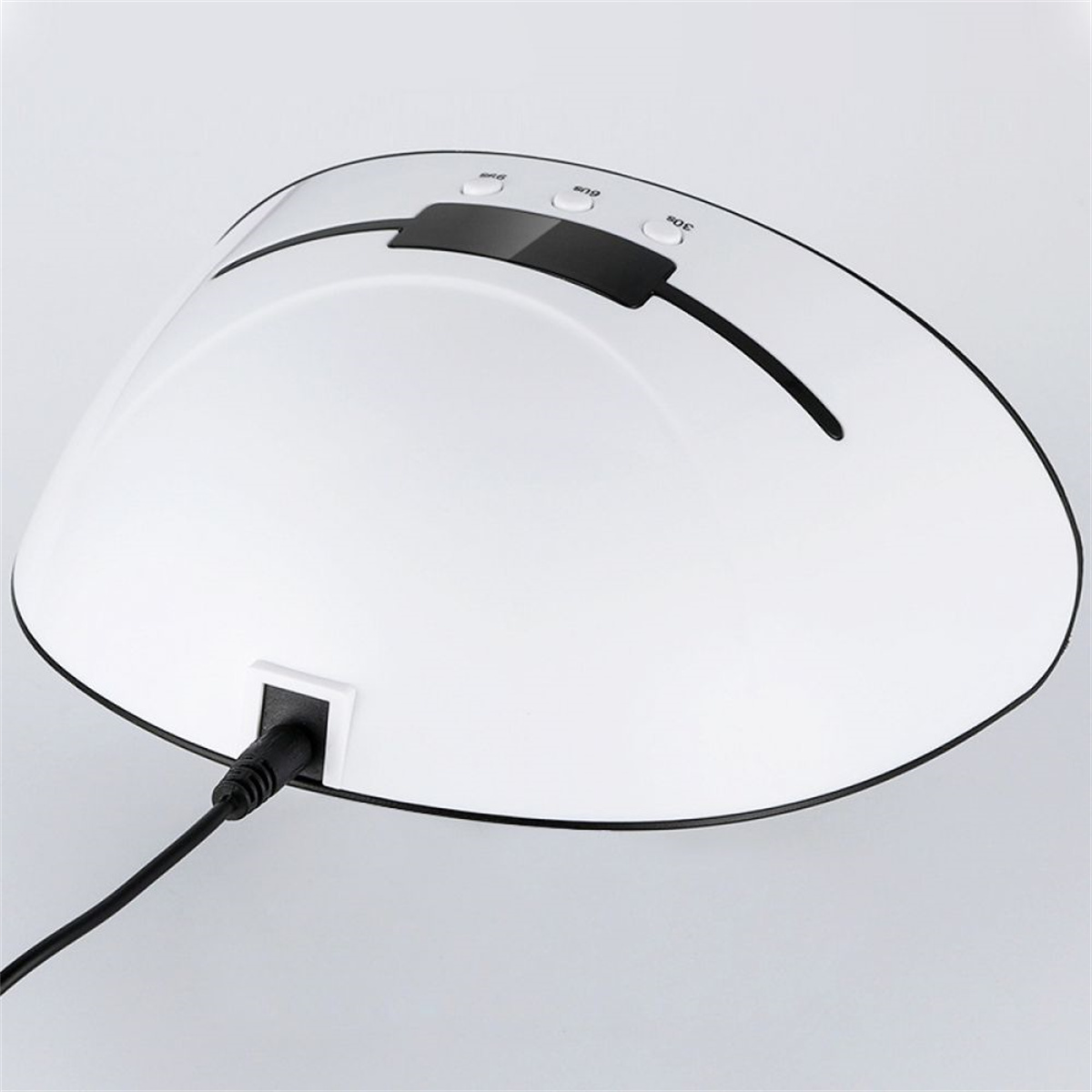 Weiße Nagellampe mit gebogenem Design und schwarzer Zierleiste, USB-Kabel angeschlossen.
