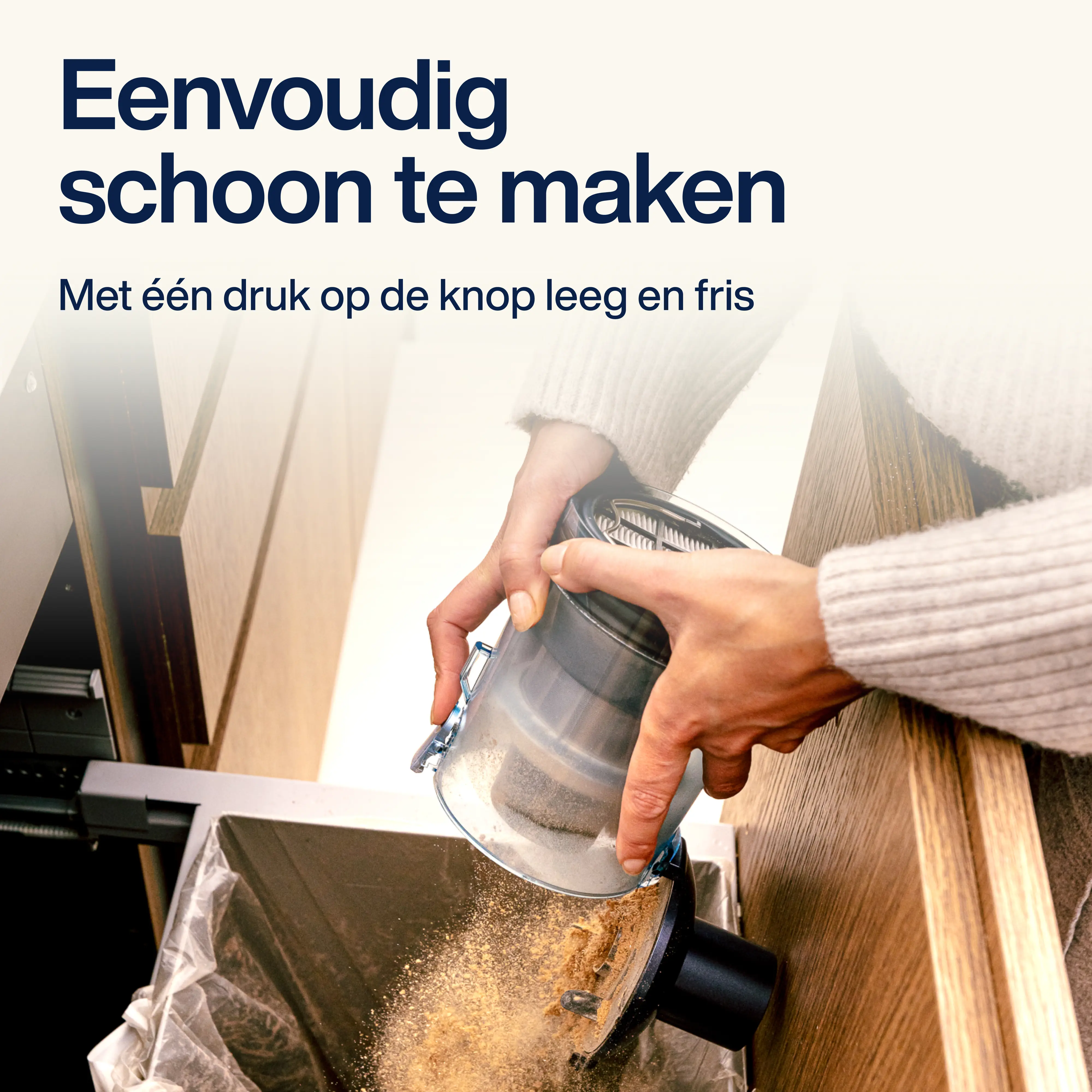 A person is emptying the dust container of a vacuum cleaner into a trash can. The container is transparent.