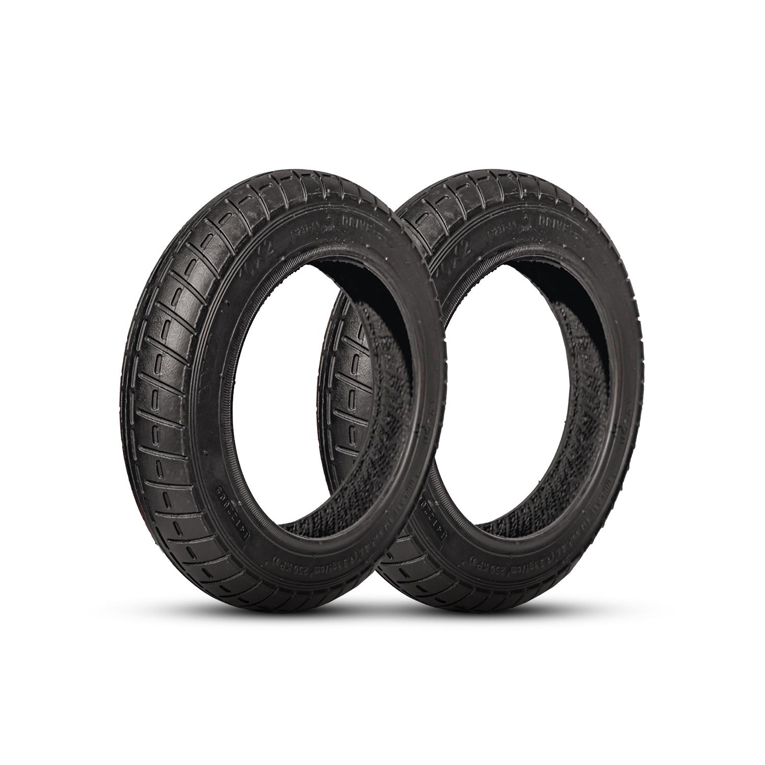 Dos neumáticos negros están uno al lado del otro sobre un fondo blanco, mostrando sus bandas de rodadura y su forma circular.