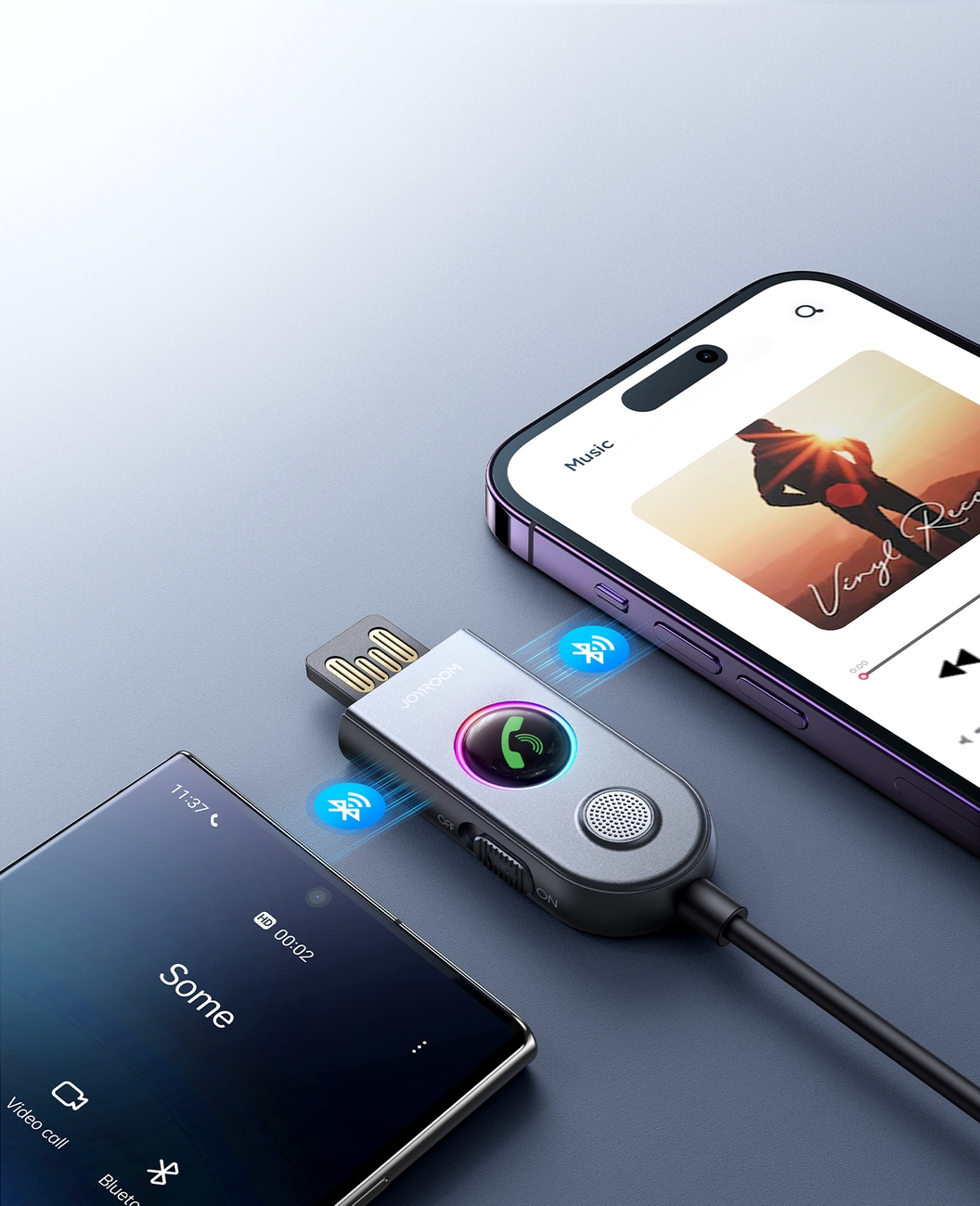 Zwei Telefone flankieren einen Joyroom-Adapter, der in einen USB-Anschluss gesteckt ist, wobei Musik- und Anrufschnittstellen angezeigt werden.