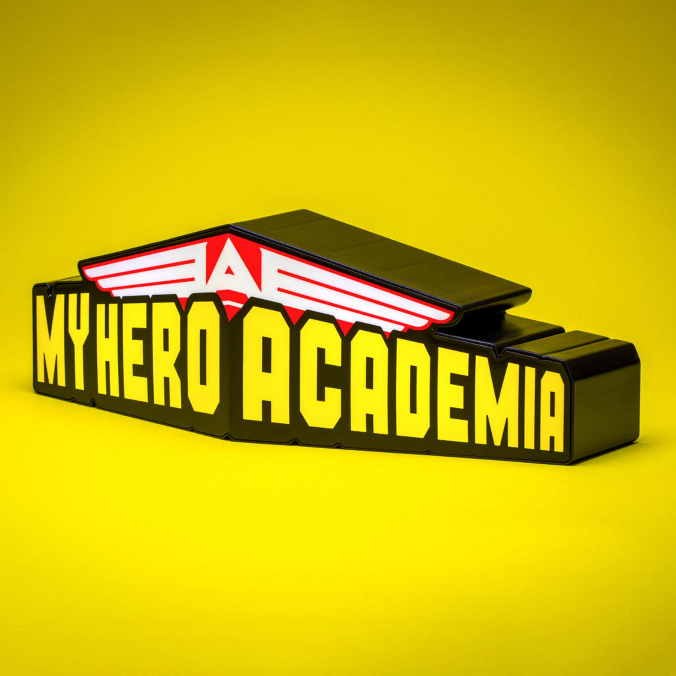"My Hero Academia"-Logo mit gelbem Text und rot-weißem Symbol auf einer gelben Oberfläche.