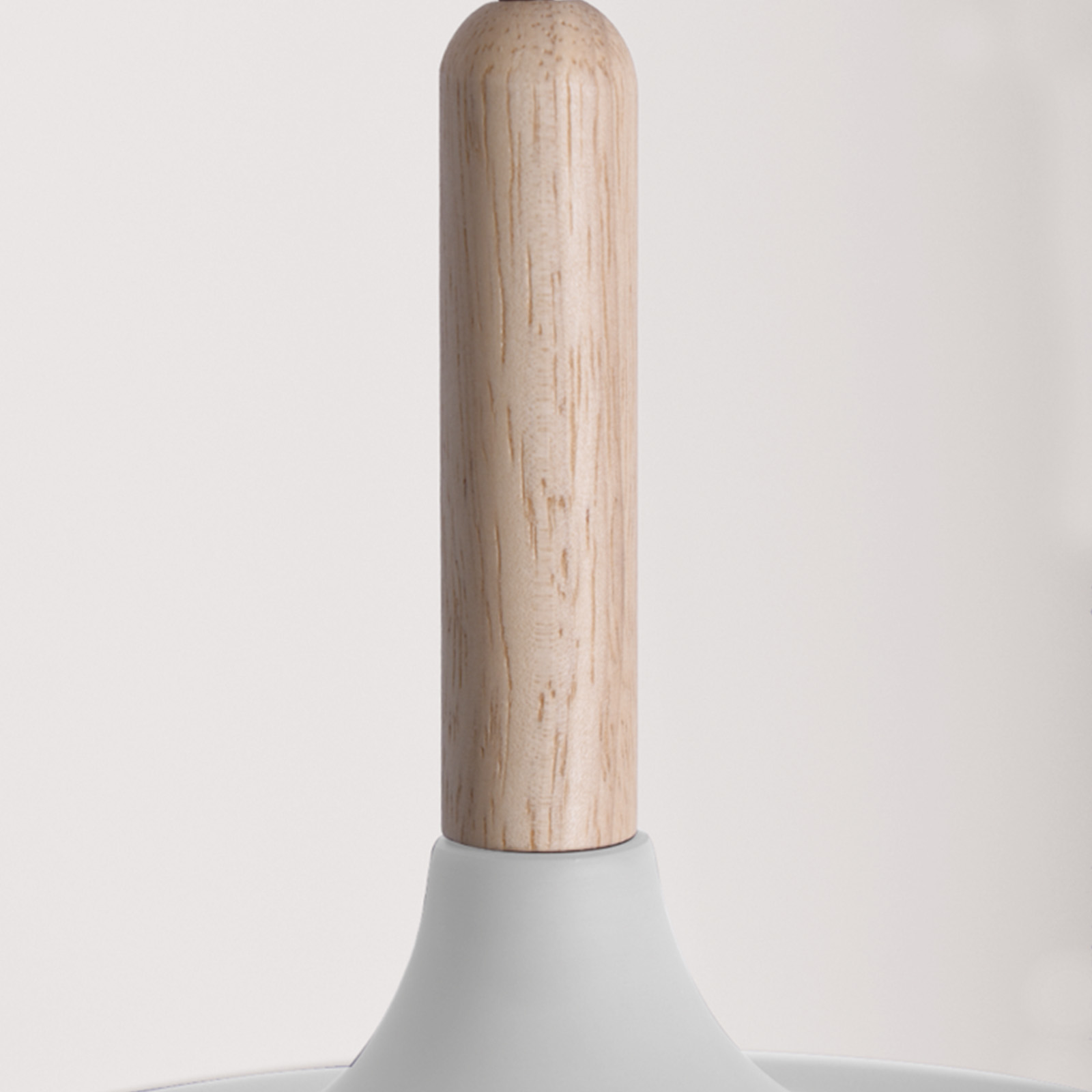 Primer plano de una lámpara de madera sobre un fondo blanco liso.