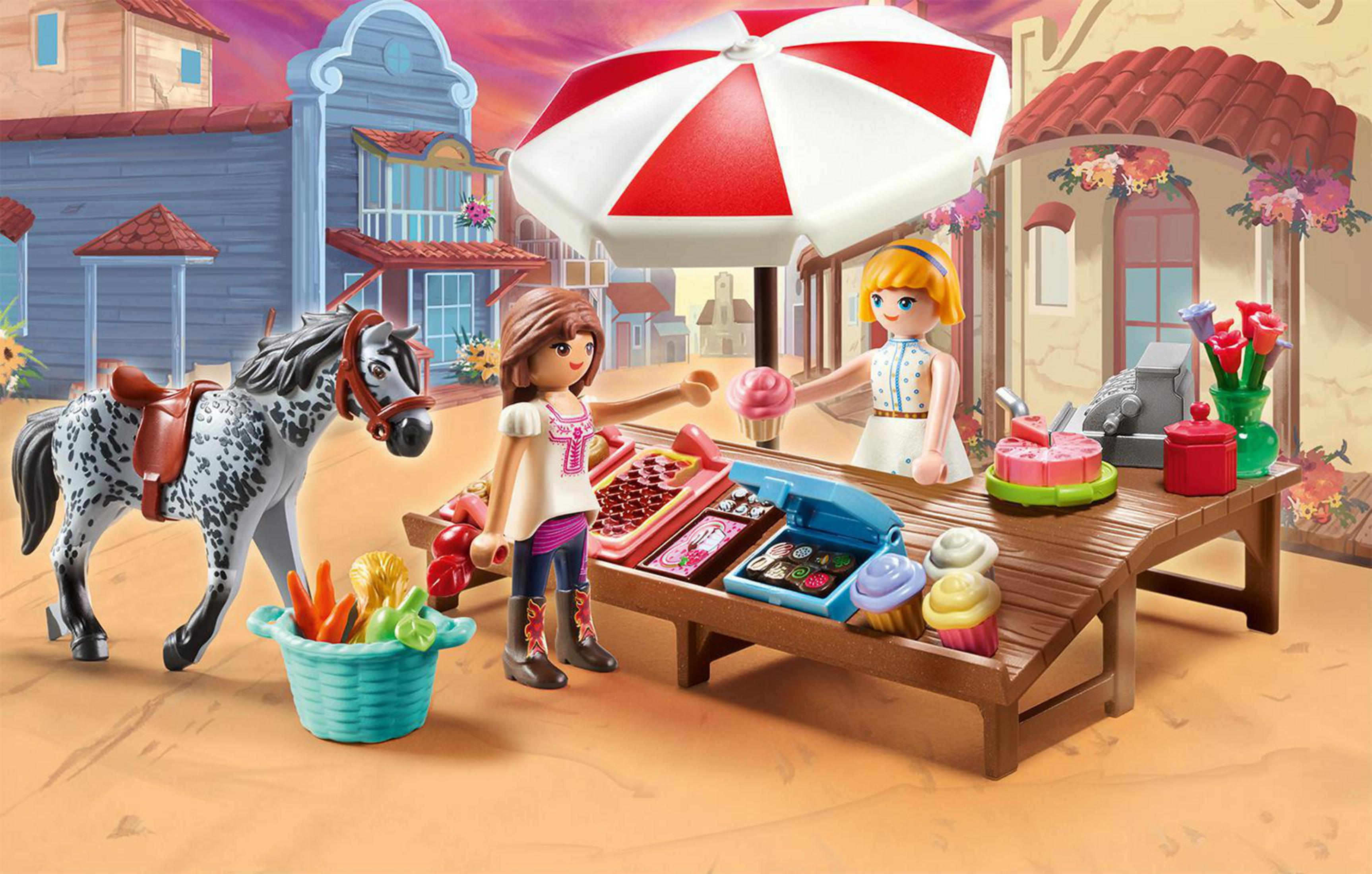 Escena de Playmobil de dos figuras comprando en un puesto de mercado, con un caballo y cestas de productos.