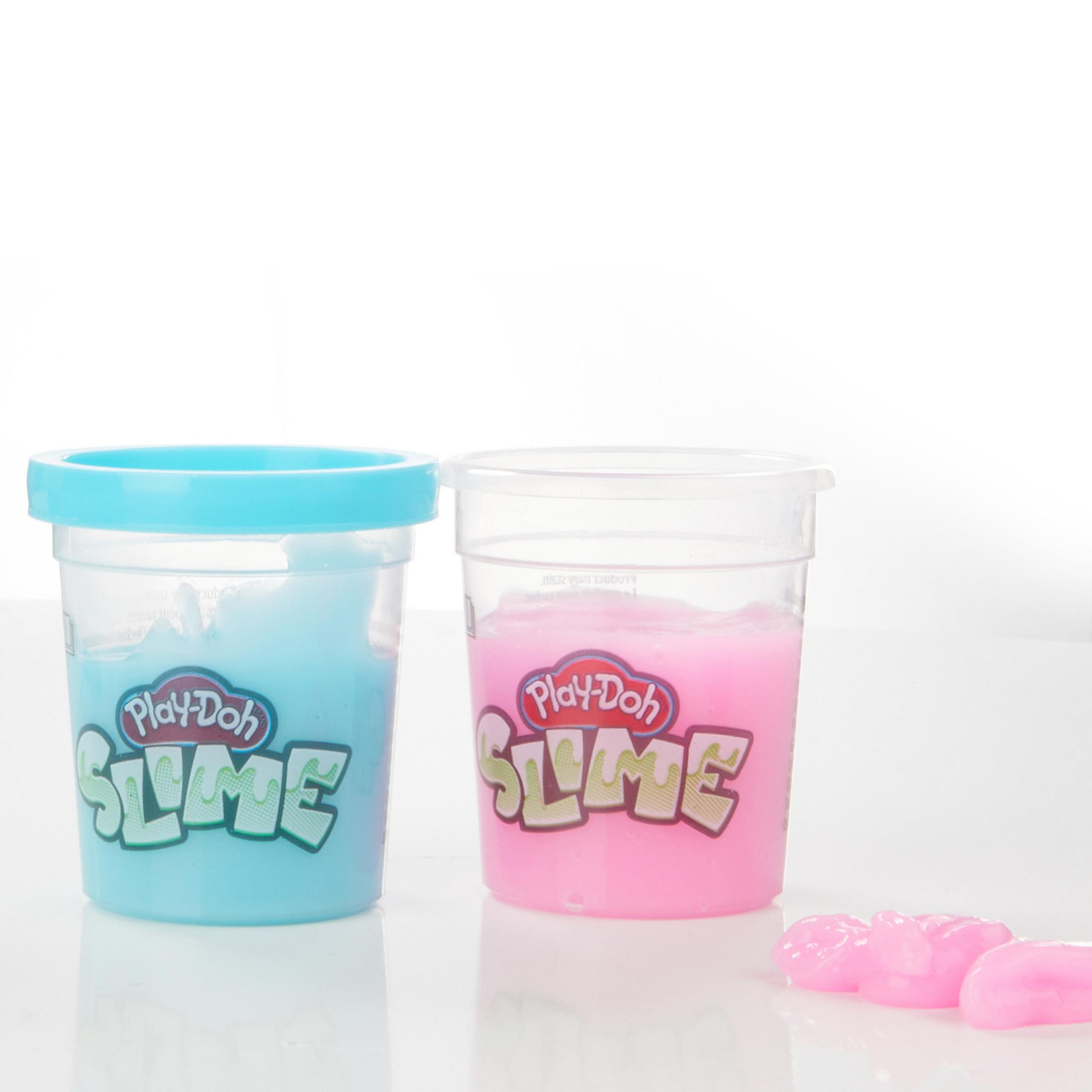 Zwei durchsichtige Behälter mit Play-Doh Slime in Blau und Pink werden auf einer weißen Oberfläche ausgestellt.