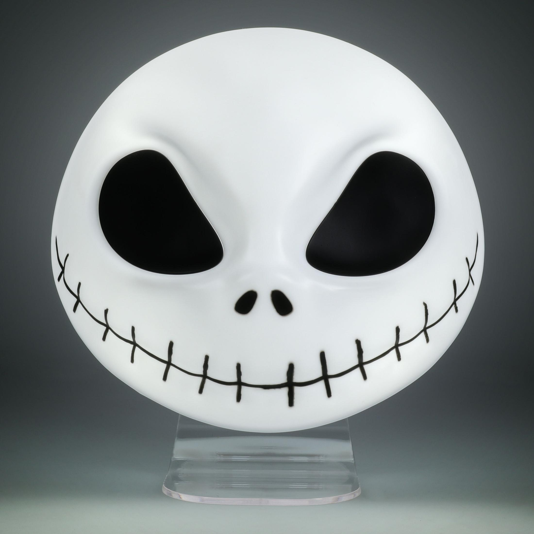 Una cabeza blanca de Jack Skellington sobre un soporte, con cuencas negras, una nariz y una boca cosida.