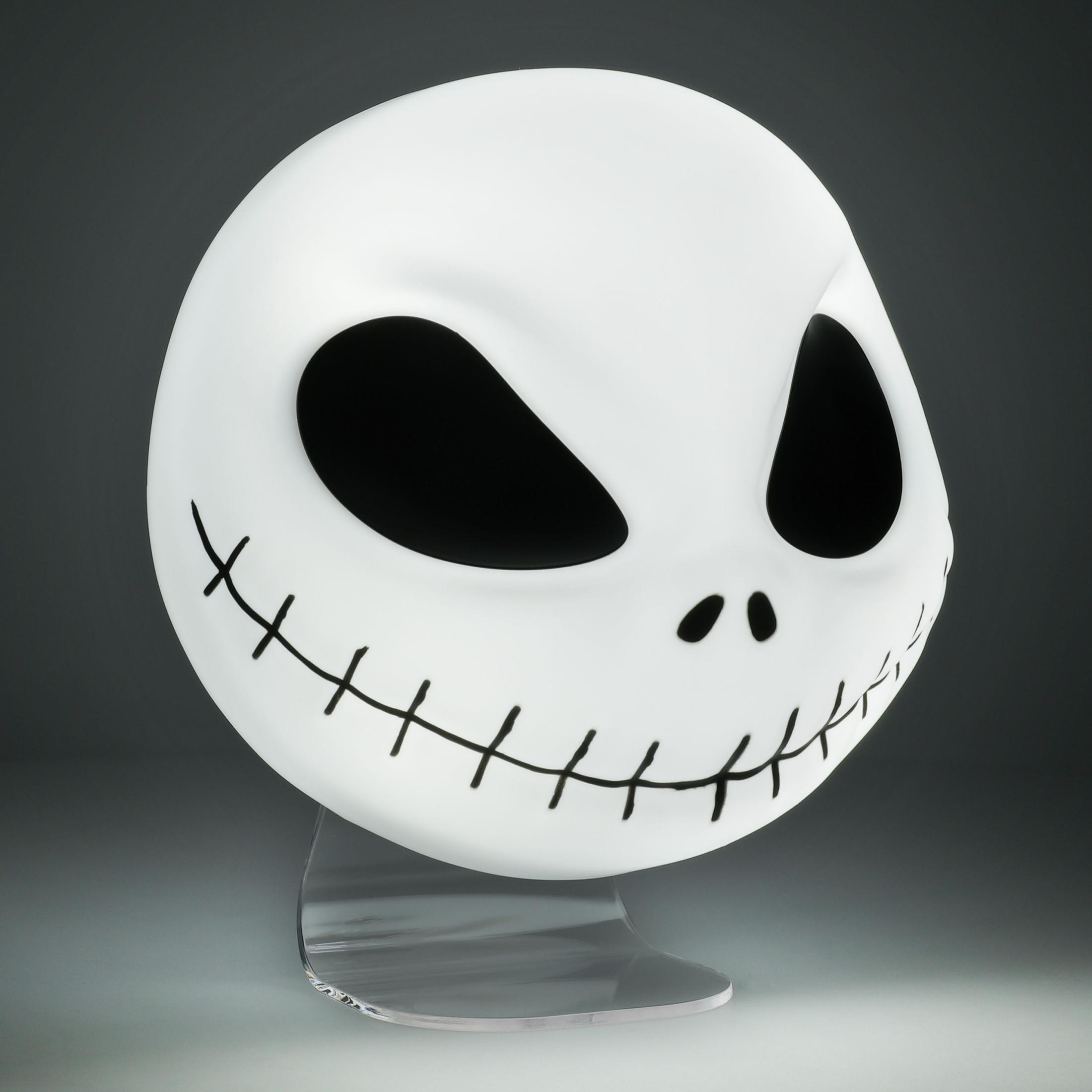 Una cabeza blanca de Jack Skellington sobre un soporte, con cuencas negras, una nariz y una boca cosida.