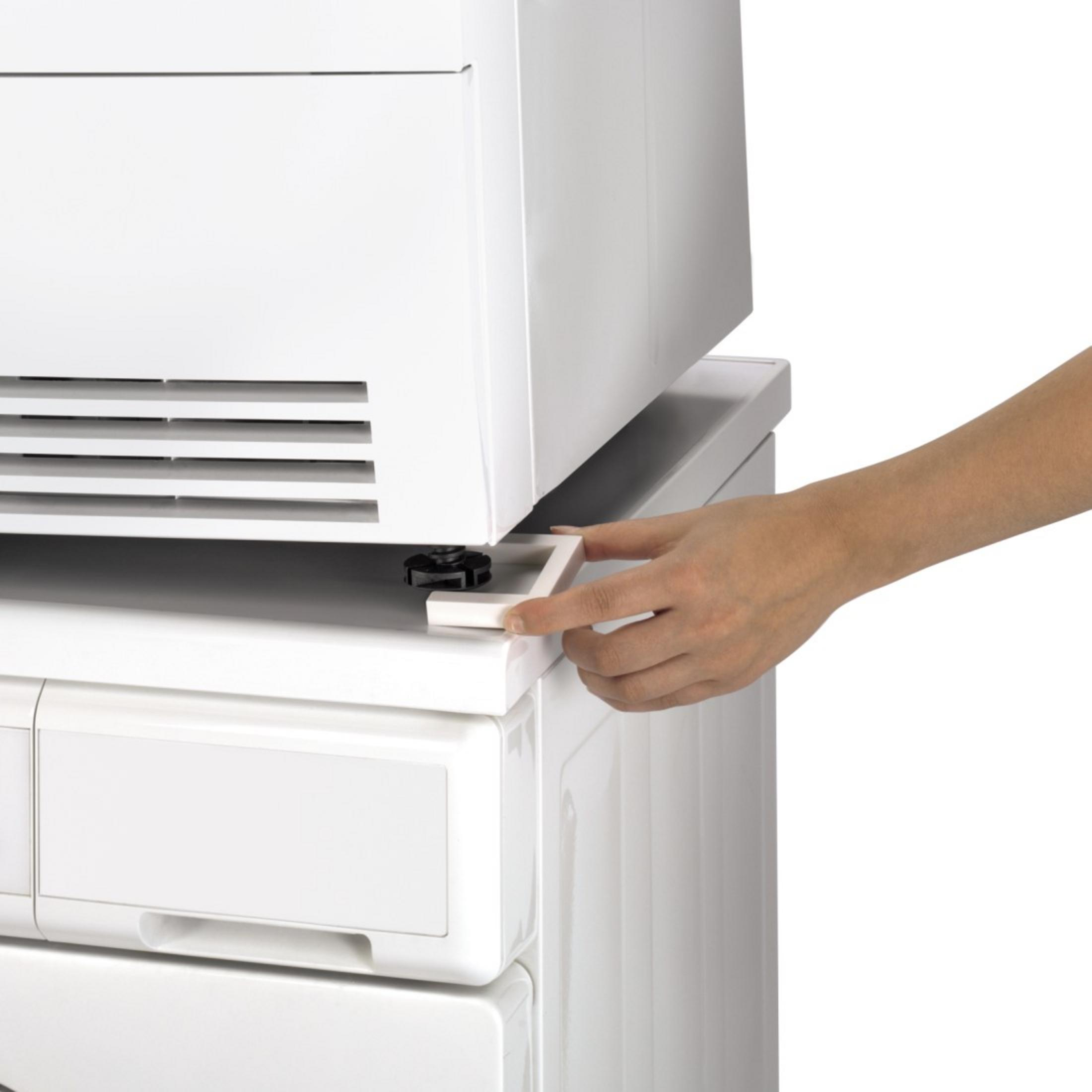 Una persona posiziona un piedino quadrato bianco sotto un elettrodomestico bianco. Sfondo bianco.