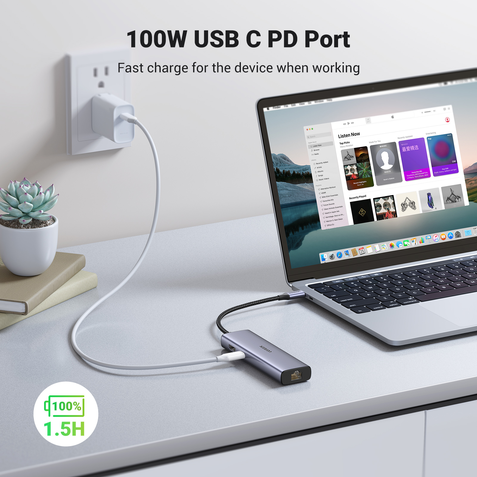 Un laptop è collegato a un hub USB-C UGREEN su una scrivania bianca con una pianta in vaso.