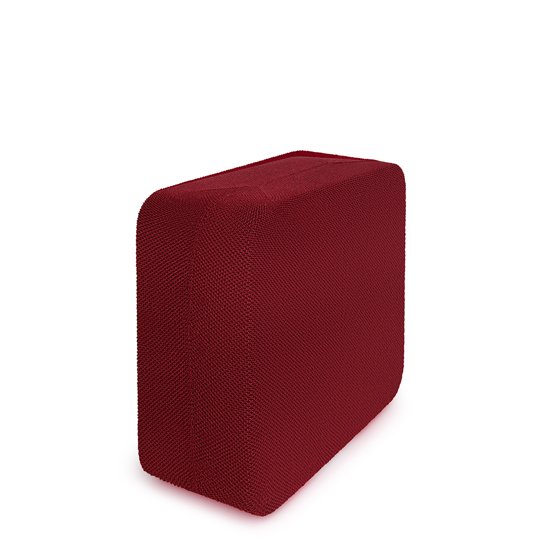 Tabouret cube tricoté marron sur une surface blanche.