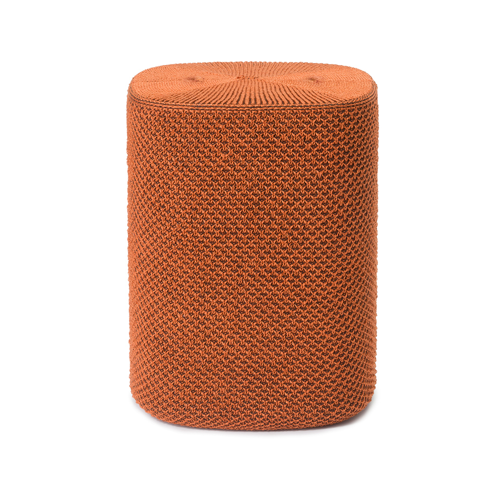 Un haut-parleur orange avec un couvercle tissé se dresse sur un fond blanc.