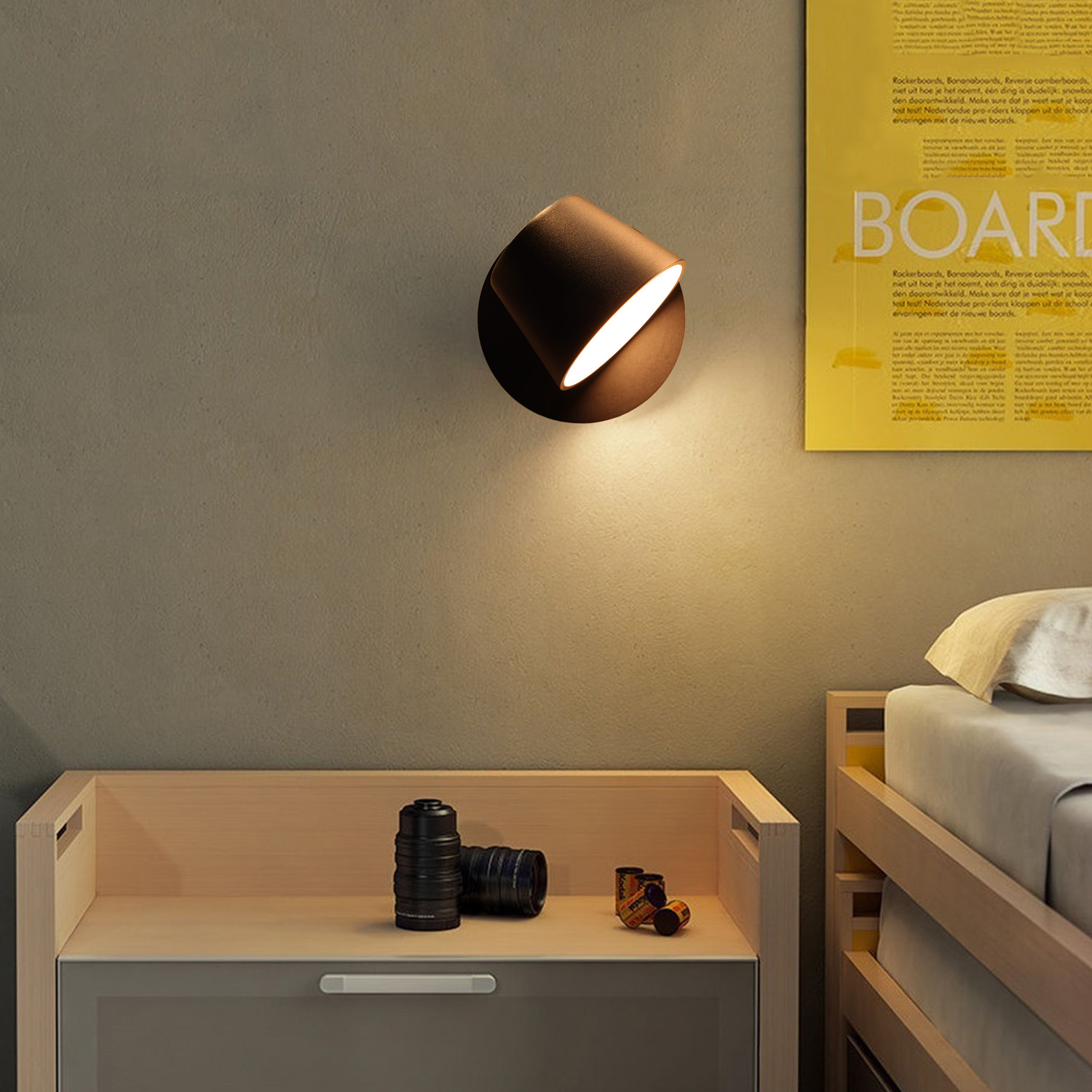 Interior de dormitorio con una lámpara de pared de bronce, una mesita de noche y un póster enmarcado.