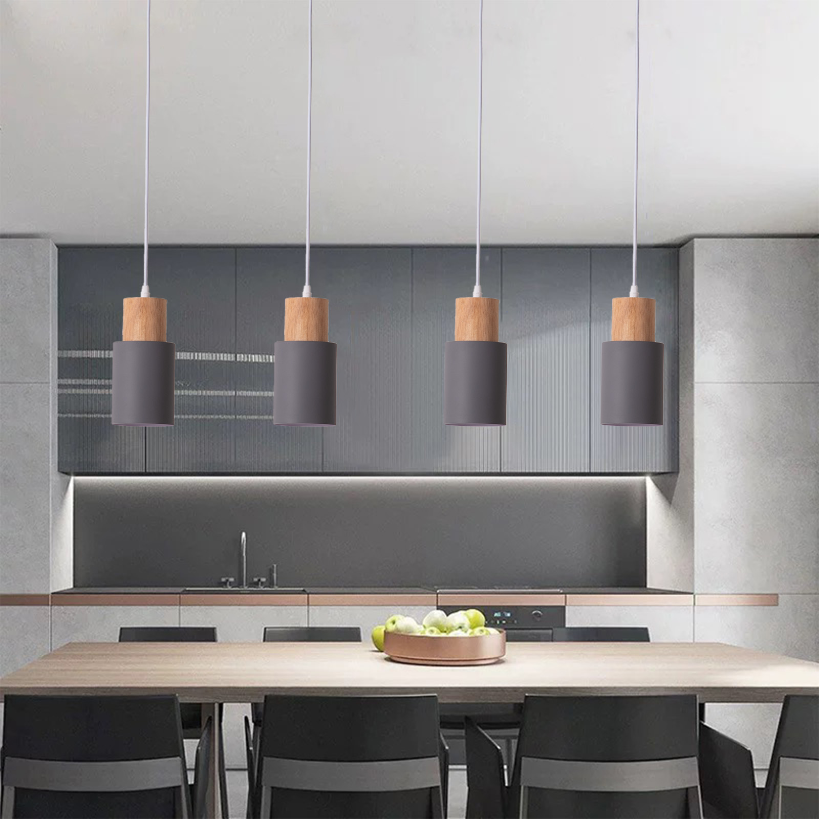 Un comedor moderno con cuatro lámparas colgantes sobre una mesa de madera con sillas negras.