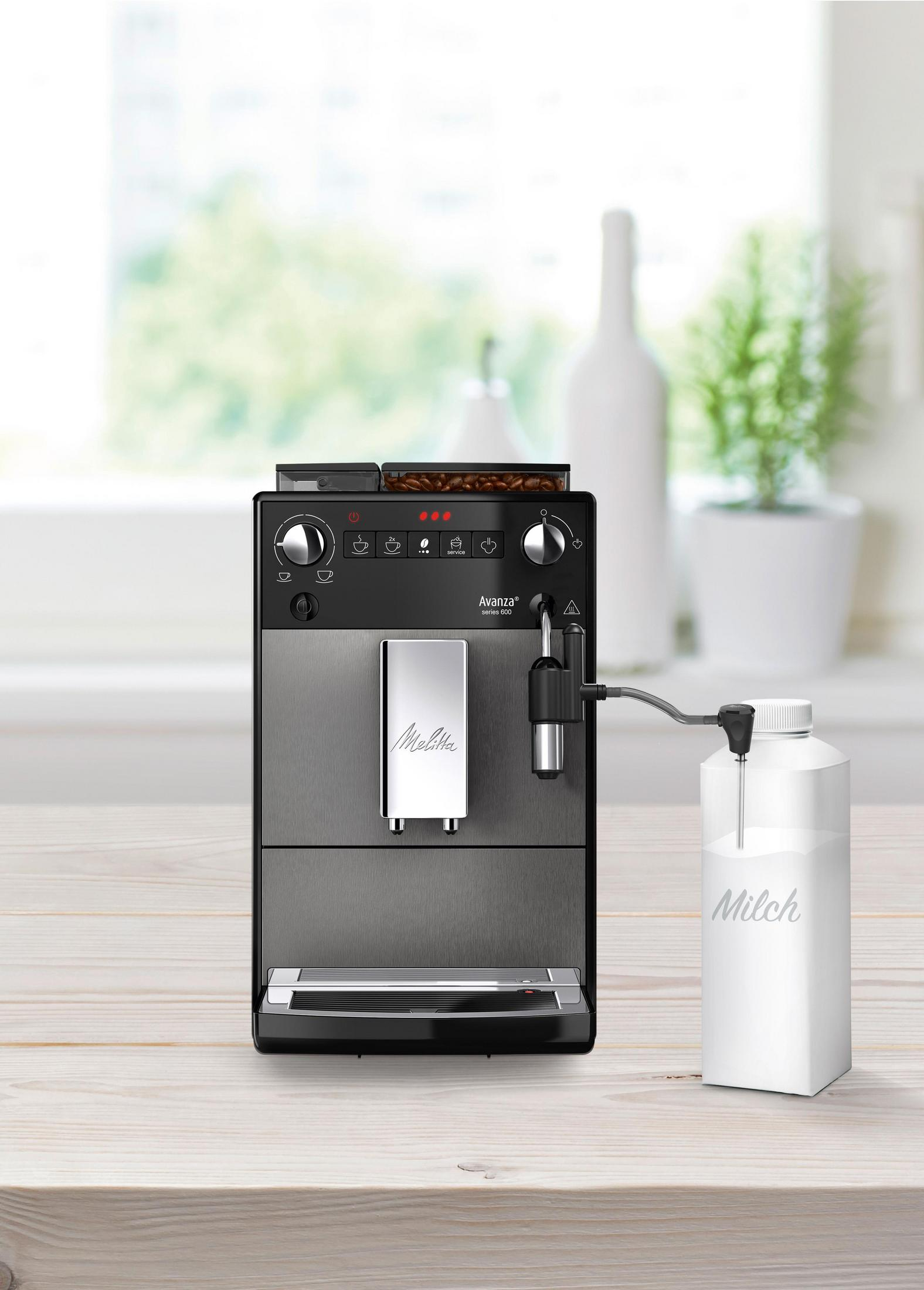 Espressomaschine, die einen geschichteten Latte ausgibt, mit einem Milchkarton daneben.