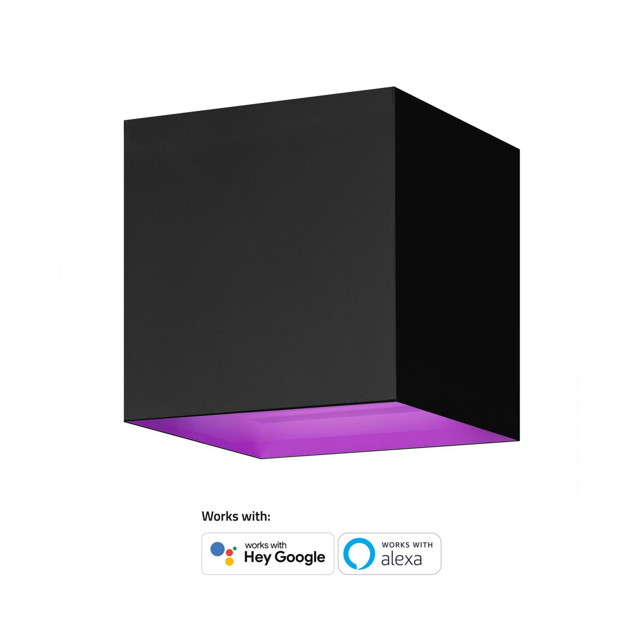 Une applique murale noire en forme de cube. Le bas émet une lumière violette. Le texte indique qu'elle fonctionne avec Hey Google et Alexa.