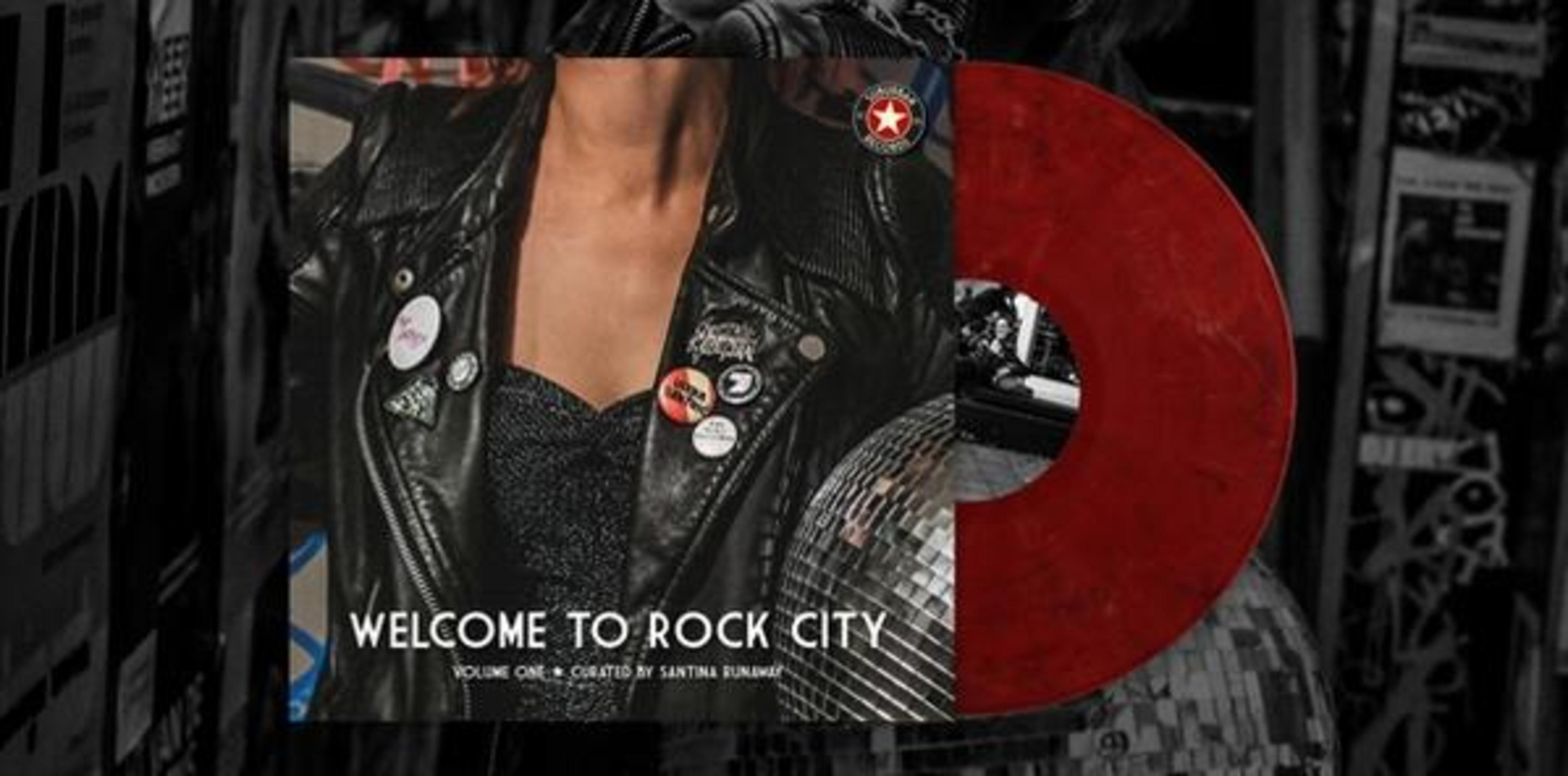 Albumhoes met een leren jas, spelden, een discobal en een rode vinylplaat. De tekst luidt "Welcome to Rock City".