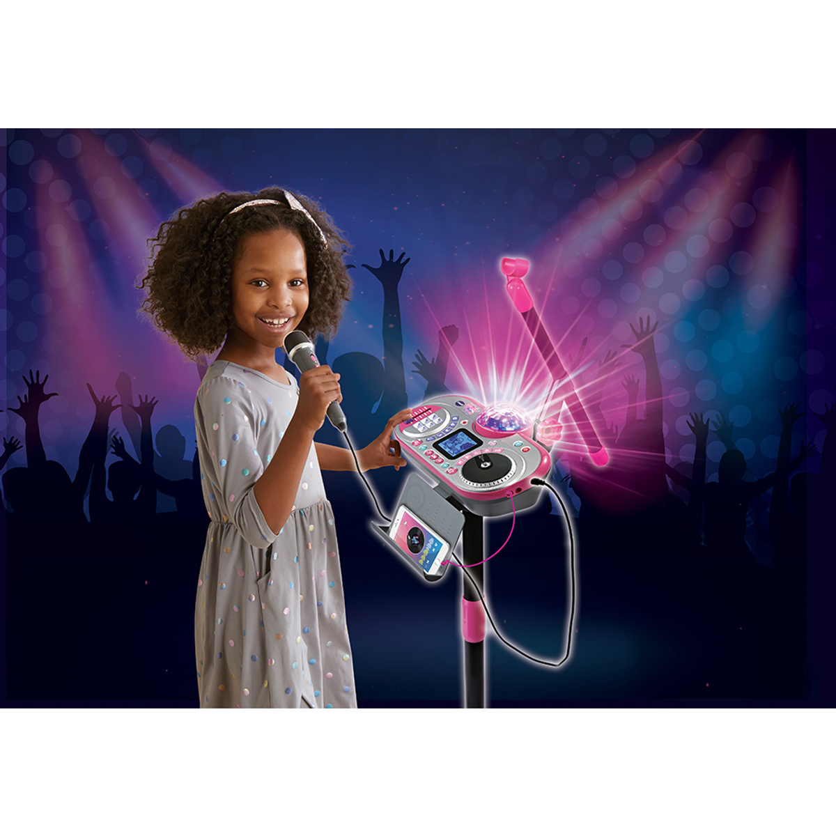 Ein Mädchen hält ein Mikrofon neben einer Karaoke-Maschine mit einer Discokugel unter Scheinwerfern.