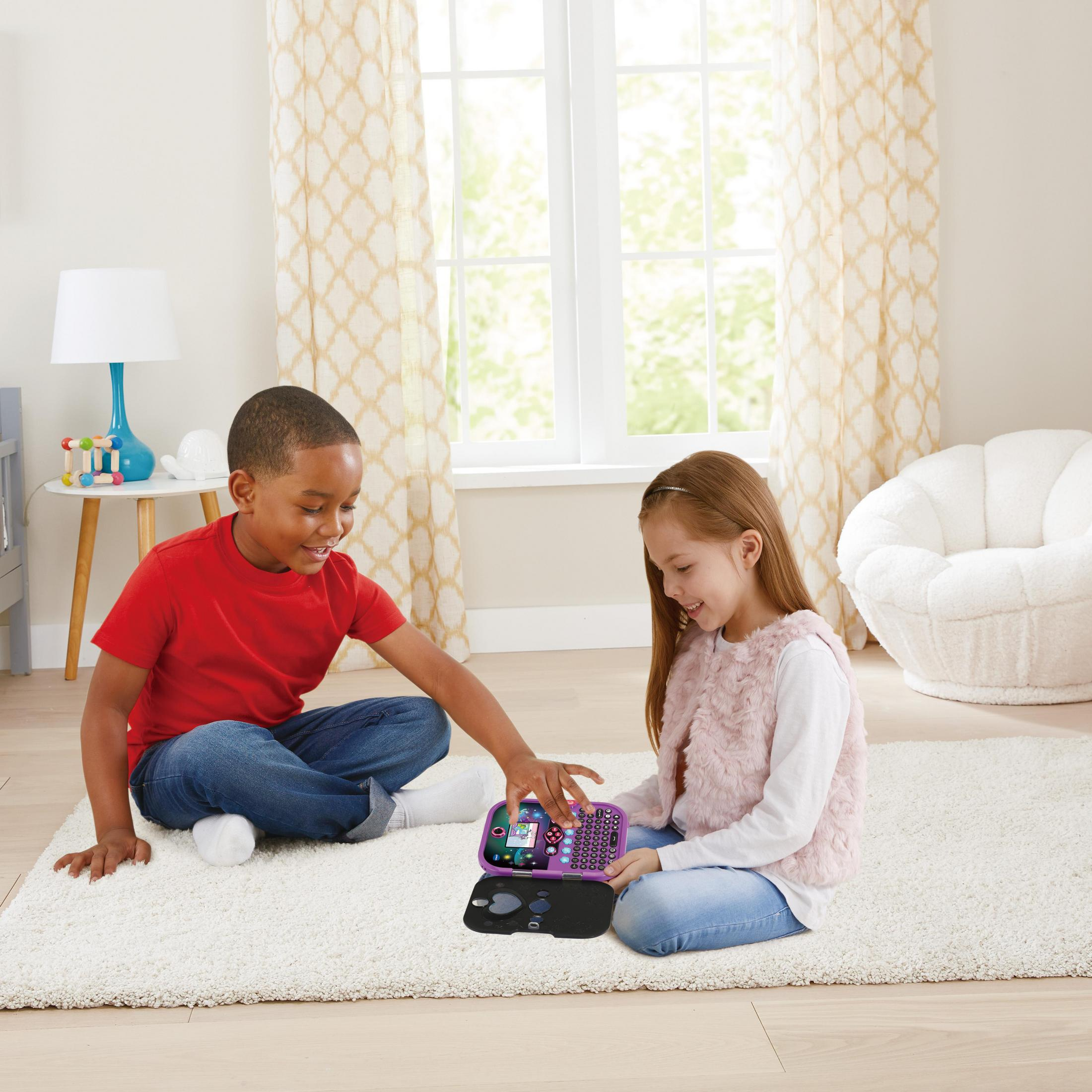 Zwei Kinder benutzen einen lila VTech Kidisecrets Safe auf einem weißen Teppich in einem Zimmer mit einem weißen Stuhl.