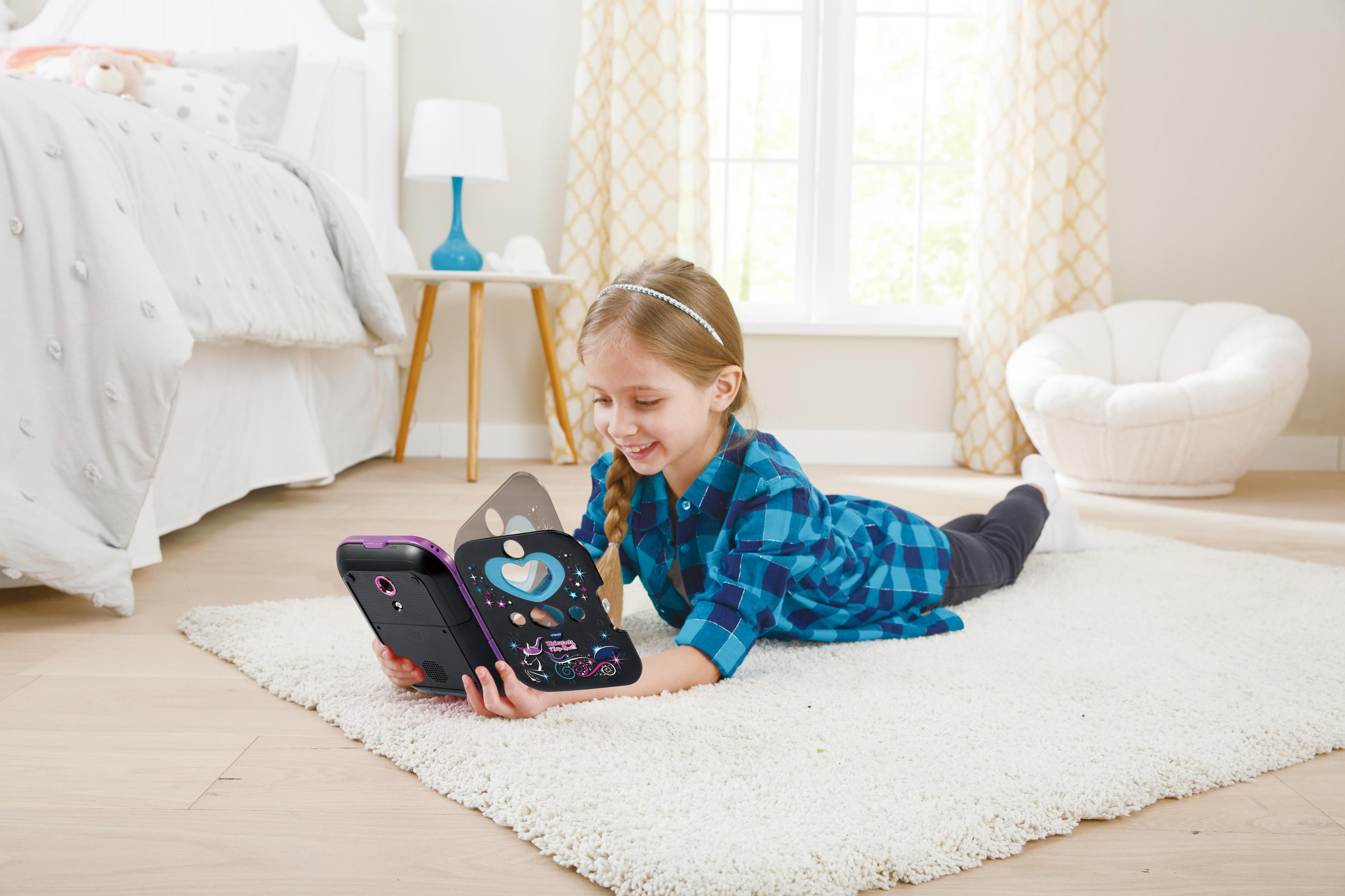 Mädchen liegt auf einem Teppich und benutzt einen offenen lila VTech Kidisecrets Safe in einem hellen Raum.