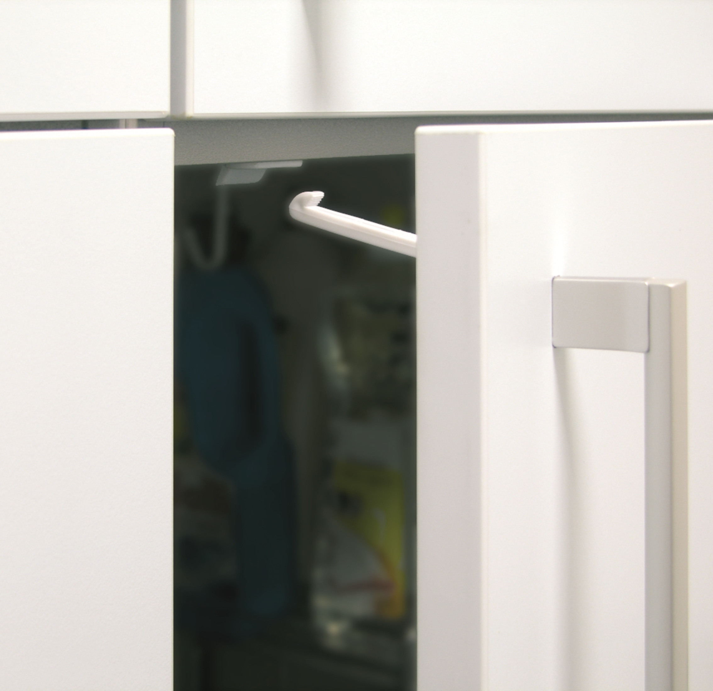 Ein weißer Schrank mit einem silbernen Griff, der einen Blick auf Gegenstände im Inneren freigibt.