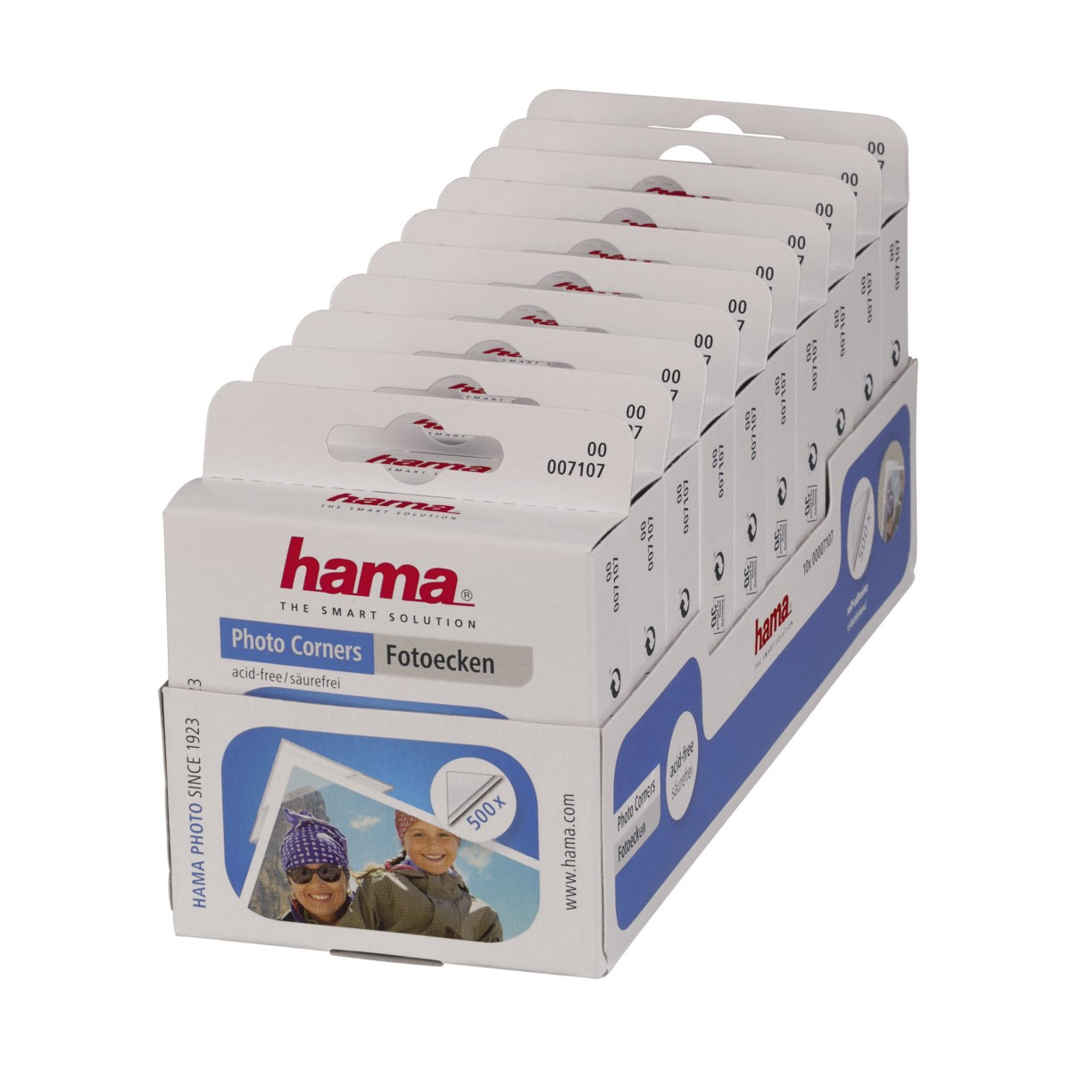 Ekspozycja narożników fotograficznych Hama w białych pudełkach z wizerunkami ludzi na opakowaniu.