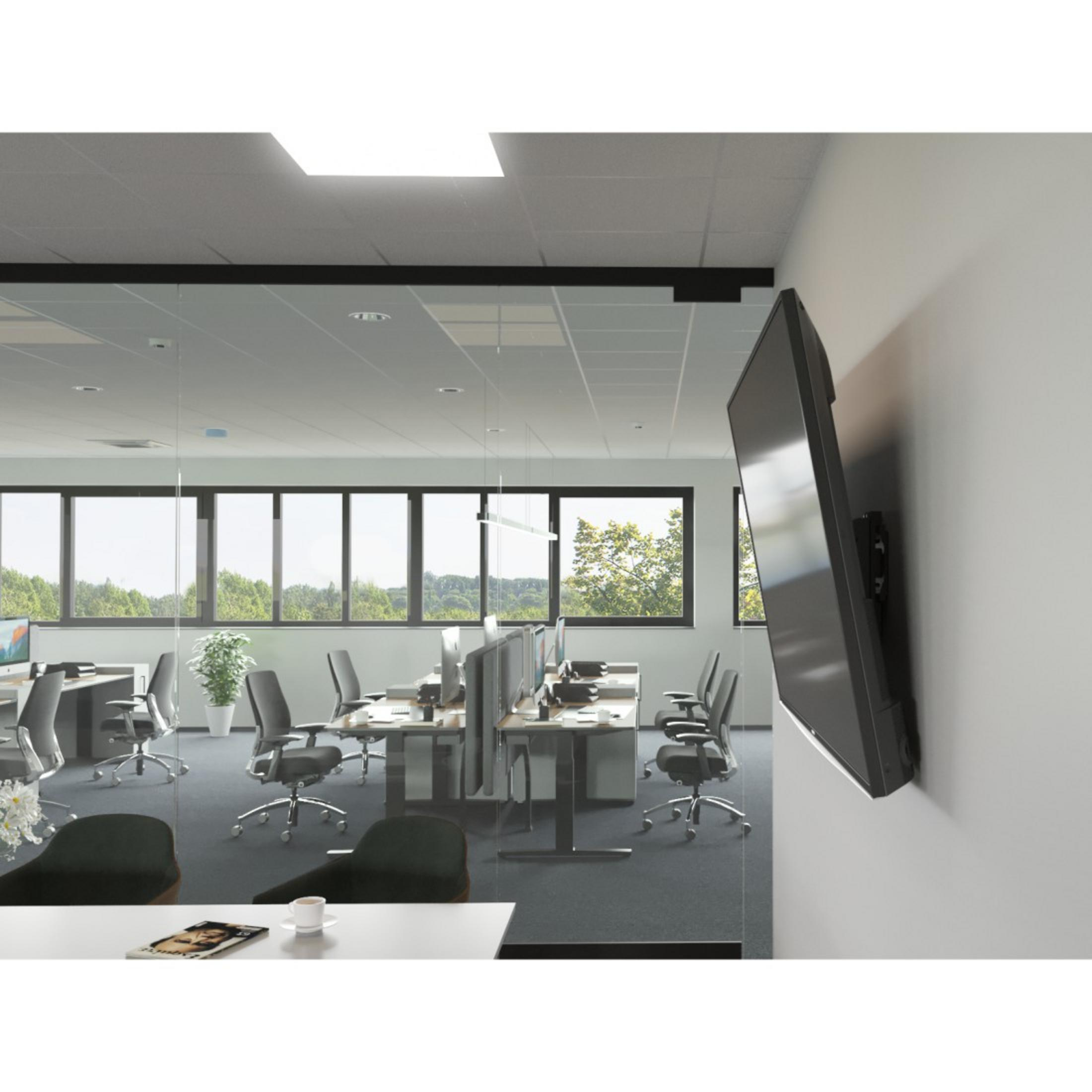Ein Fernseher, der in einem Büro an einer weißen Wand montiert ist. Der Fernseher ist schwarz, abgewinkelt, modernes Büro.