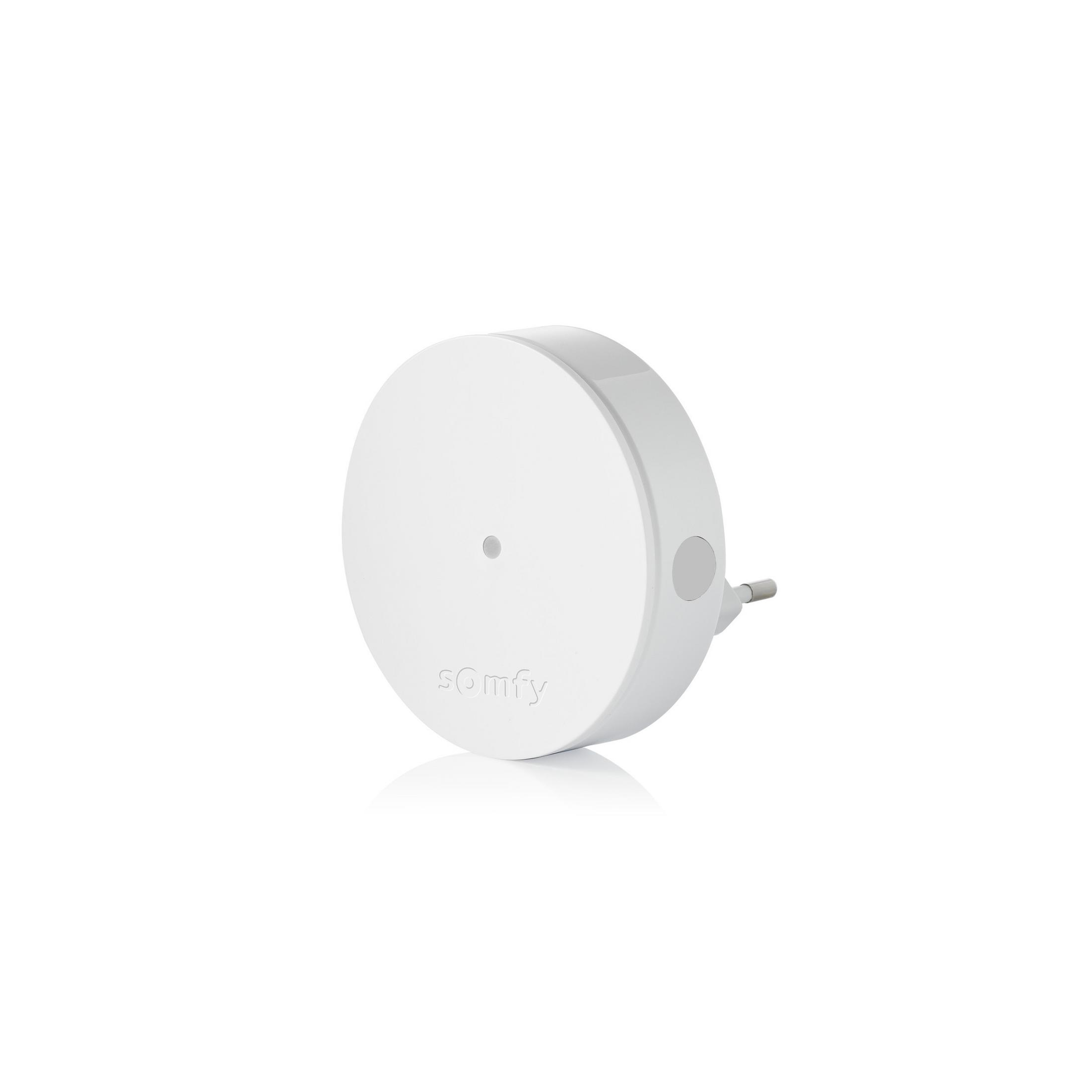 Ein weißes Somfy-Gerät mit einem Stecker auf der rechten Seite, platziert auf einer weißen Oberfläche.