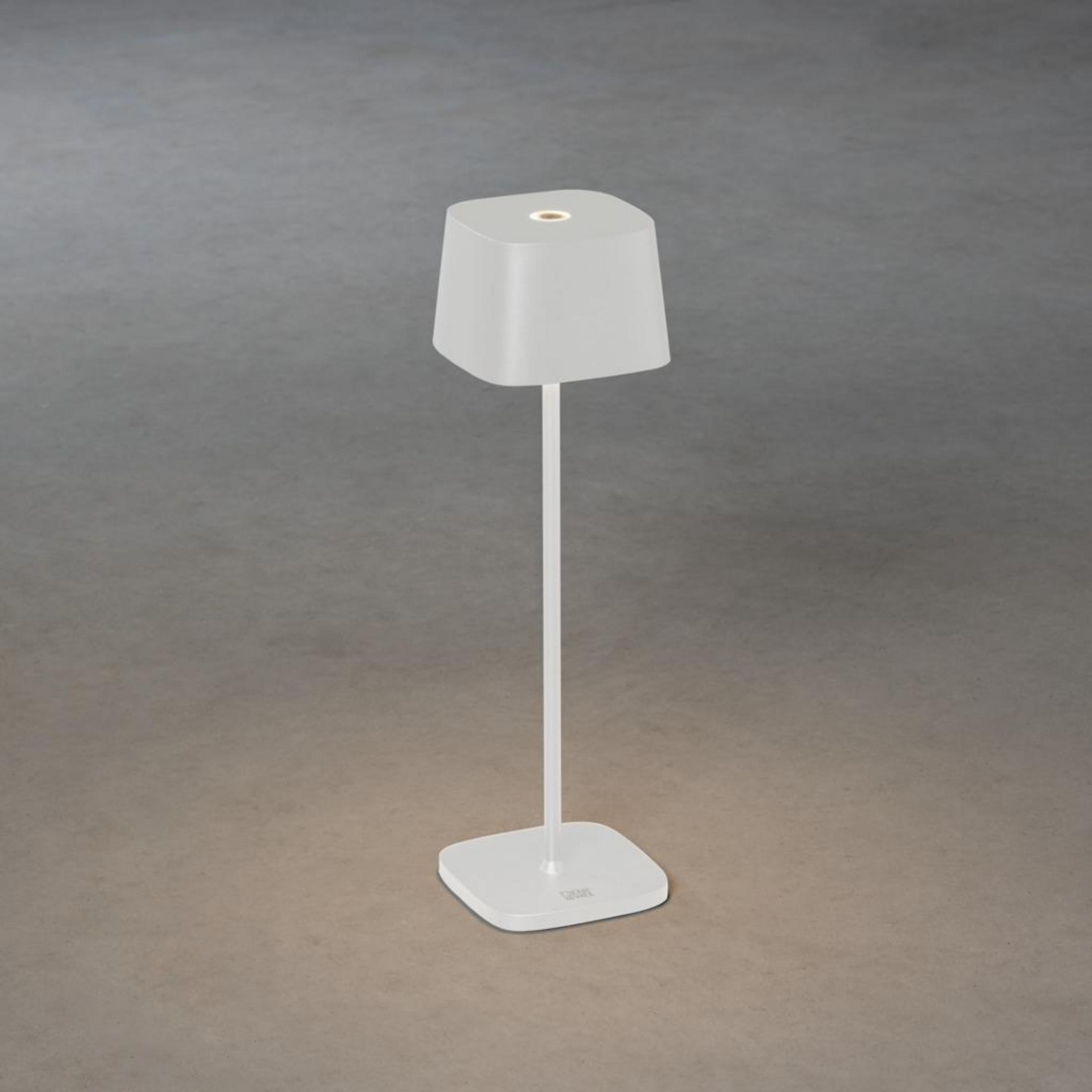 Eine weiße Lampe mit quadratischem Sockel ist vor einem grauen Hintergrund abgebildet.