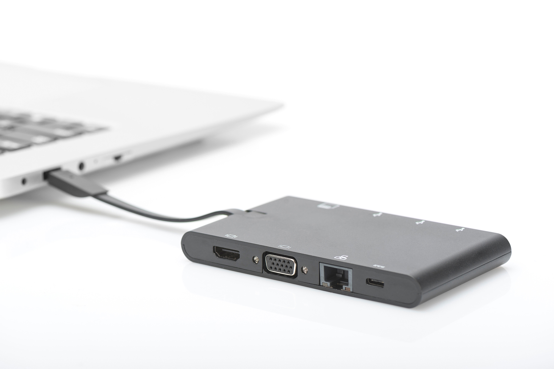 Ein schwarzer Multiport-Adapter ist auf weißem Hintergrund mit einem Laptop verbunden.