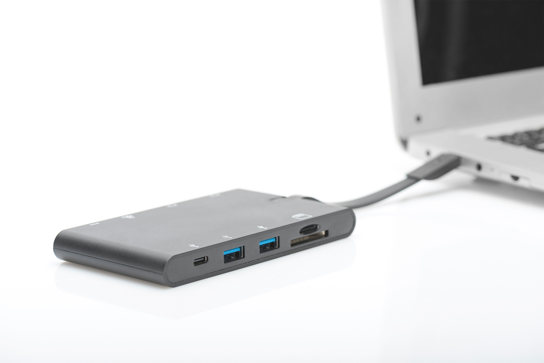 Ein schwarzer Multiport-Adapter ist auf weißem Hintergrund mit einem Laptop verbunden.