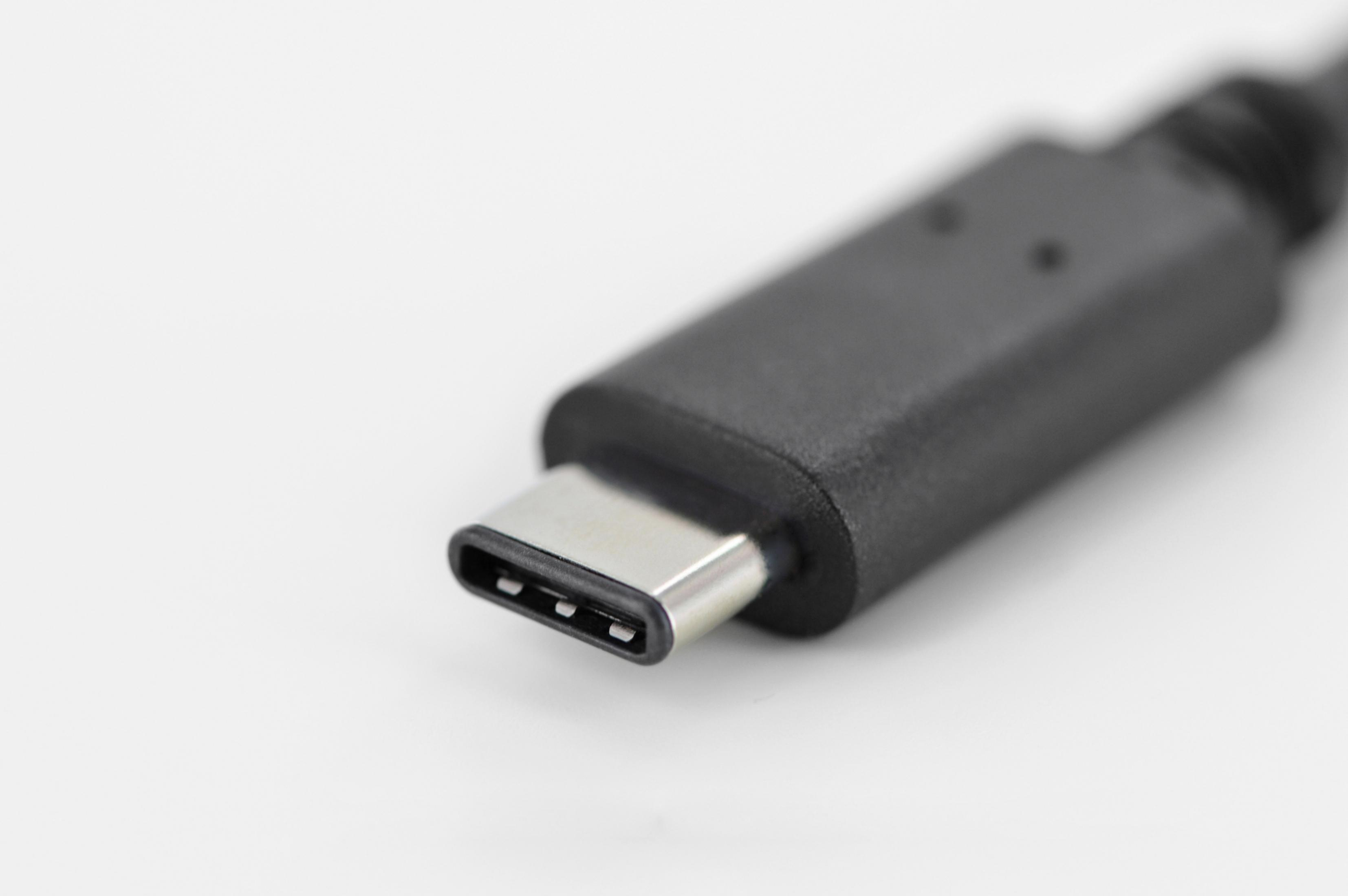 Nahaufnahme eines schwarzen USB-C-Steckers auf weißem Hintergrund. Der Stecker ist zur Kamera ausgerichtet.