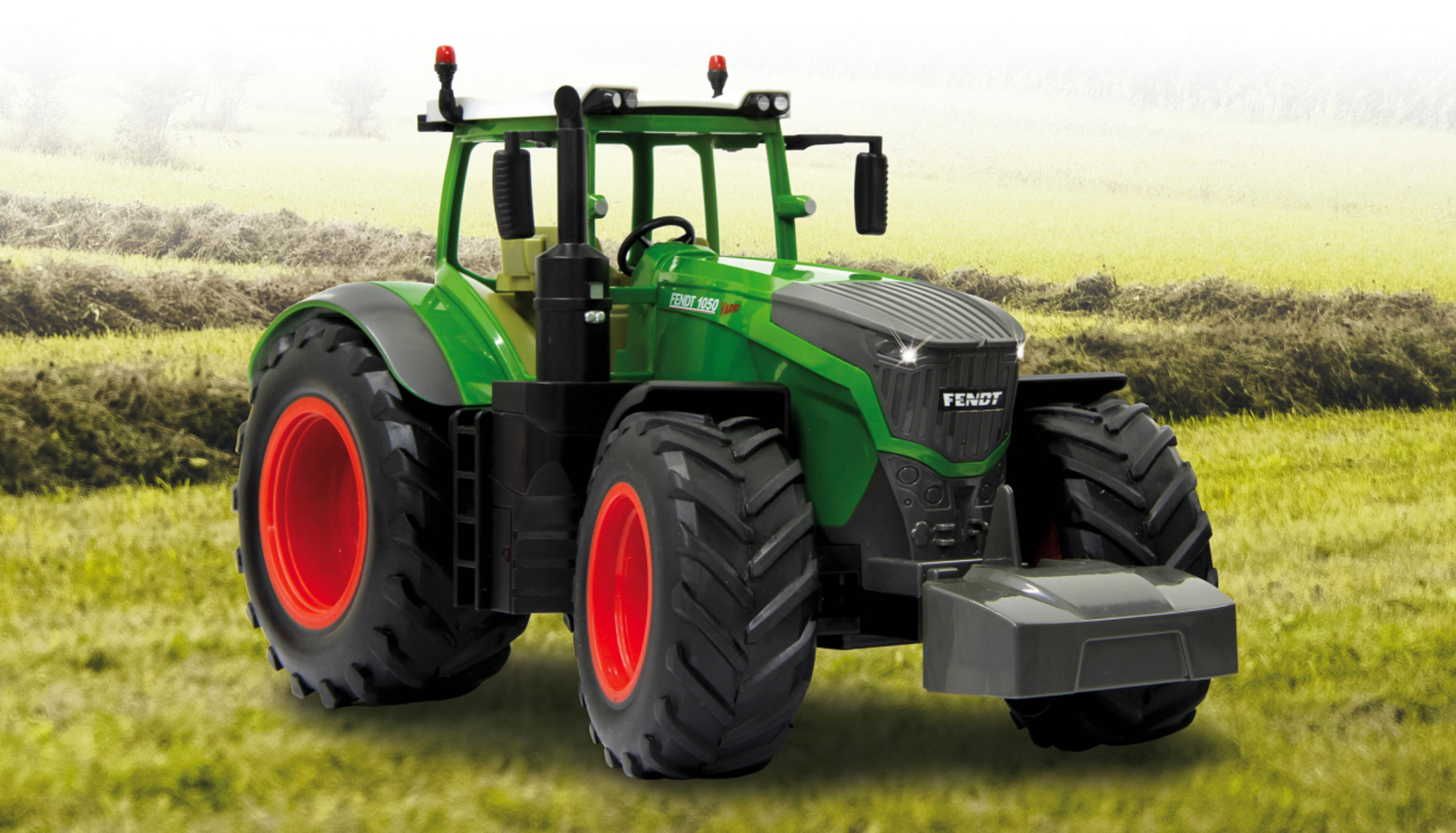 Se muestra un tractor de juguete verde con ruedas rojas sobre un fondo de hierba.