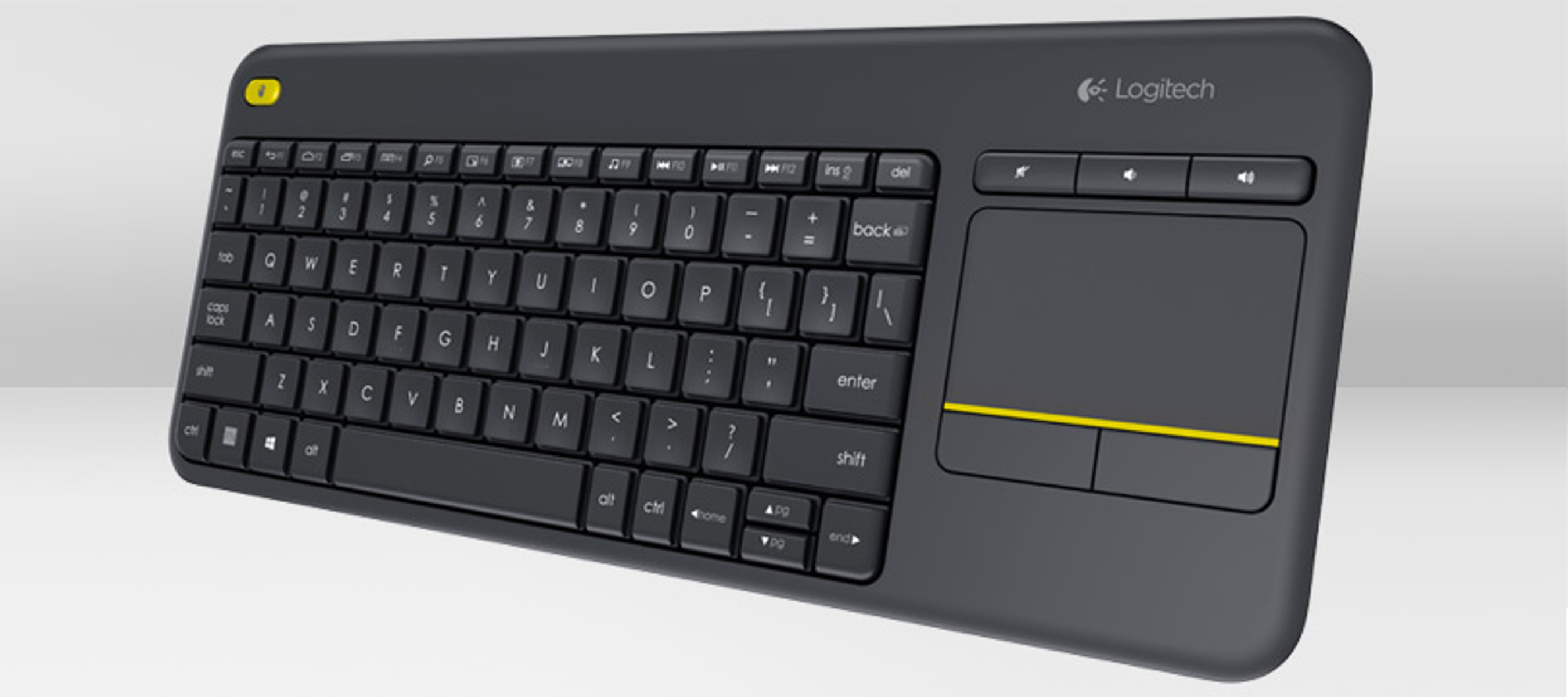 Eine schwarze Logitech-Tastatur mit gelbem Akzent, Touchpad und Funktionstasten. Sie ist auf einer weißen Oberfläche abgewinkelt.