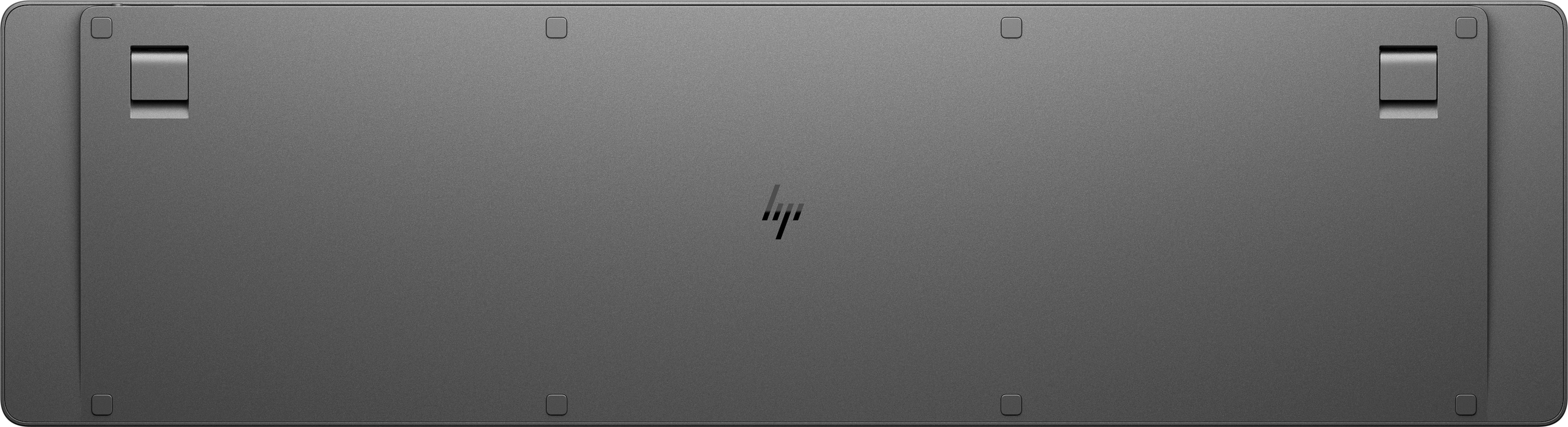 Die Unterseite einer grauen Tastatur mit einem HP-Logo in der Mitte befindet sich auf einer weißen Oberfläche.