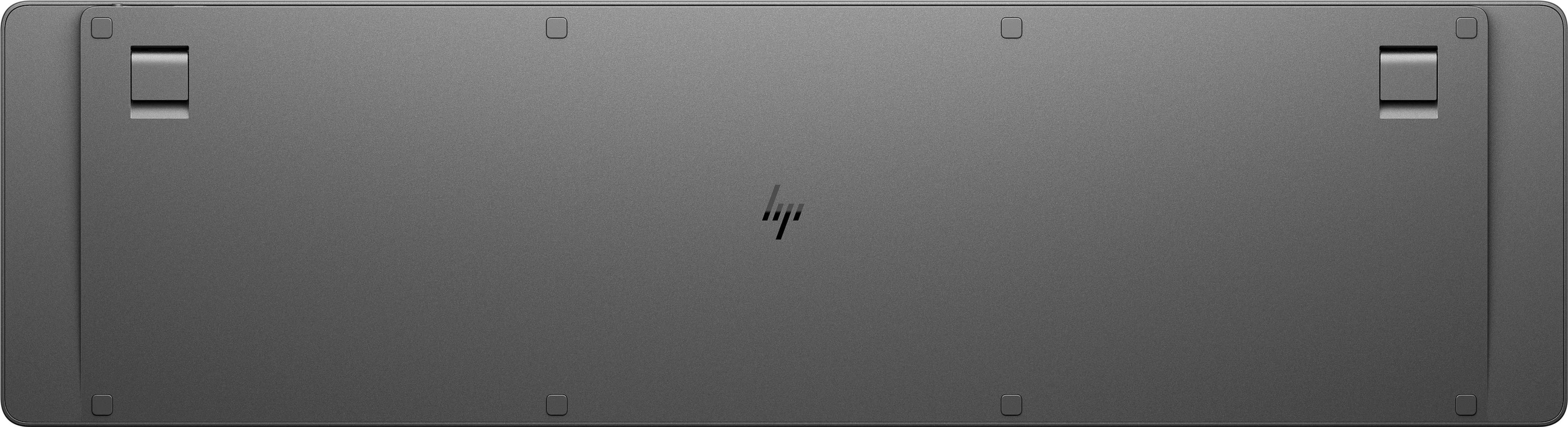 Die Unterseite einer grauen Tastatur mit einem HP-Logo in der Mitte befindet sich auf einer weißen Oberfläche.