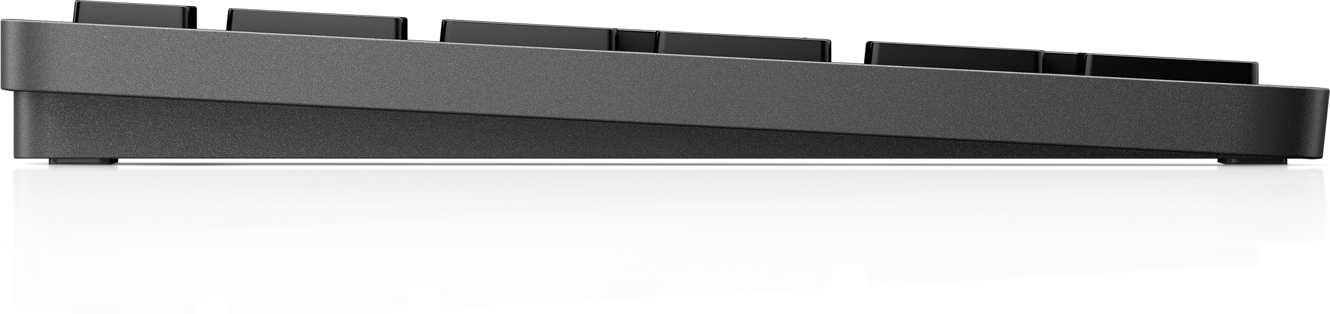 Eine Seitenansicht einer grauen Tastatur mit einem flachen, flachen Design auf Weiß.